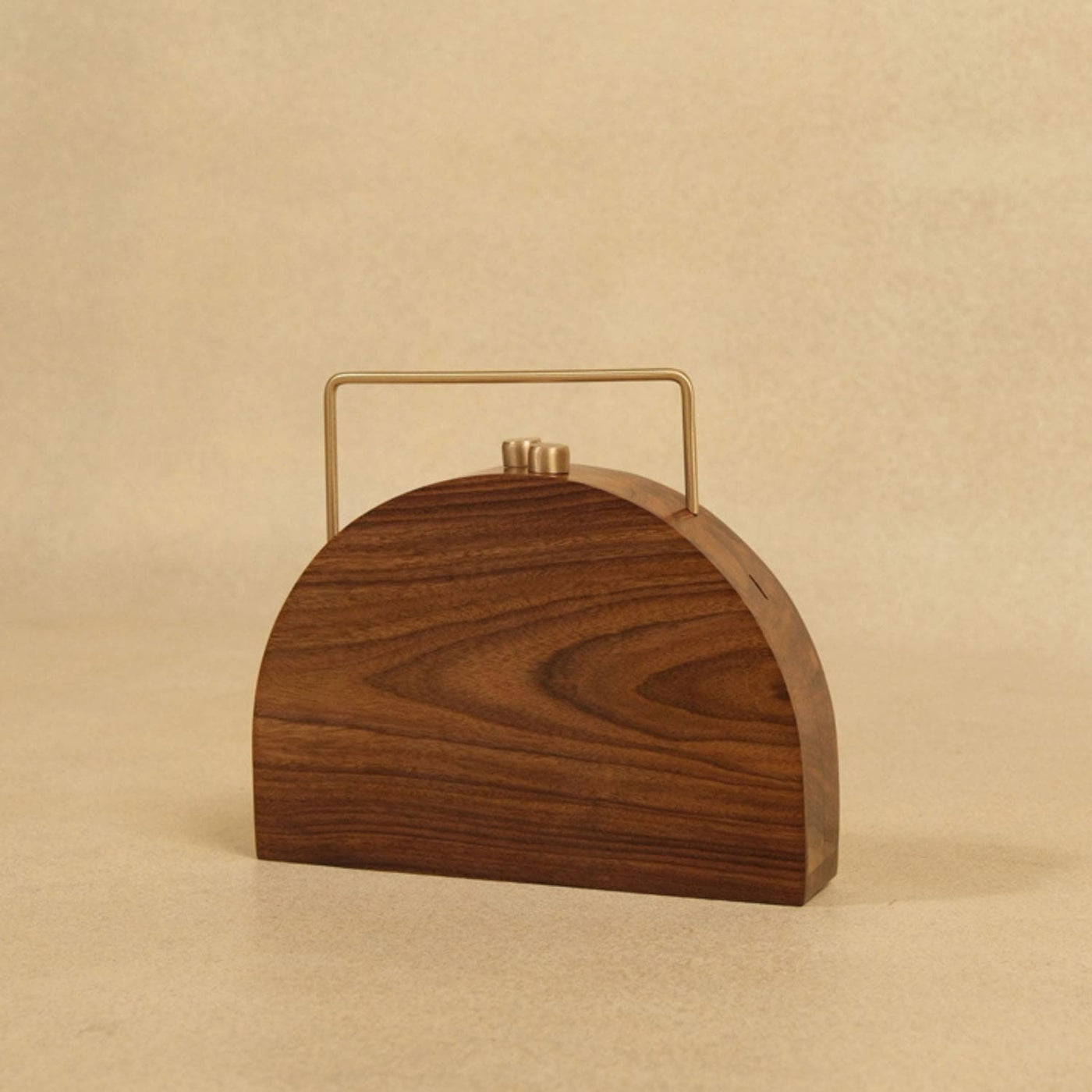 Wooden handbag with a gold handle on a beige background