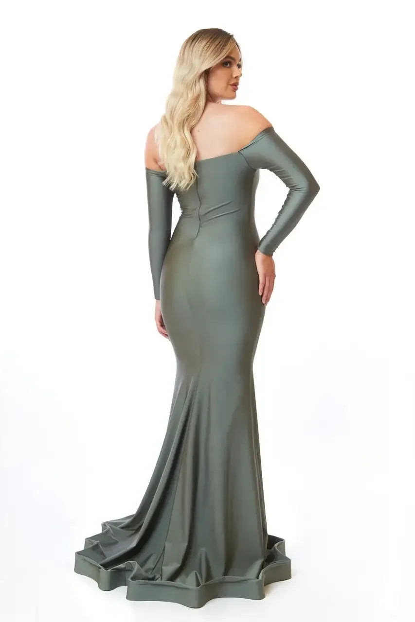 A figure in a fitted, off-shoulder, green evening gown stands with their back facing the viewer. The dress has a flared bottom and a smooth, shiny texture, set against a plain white background.