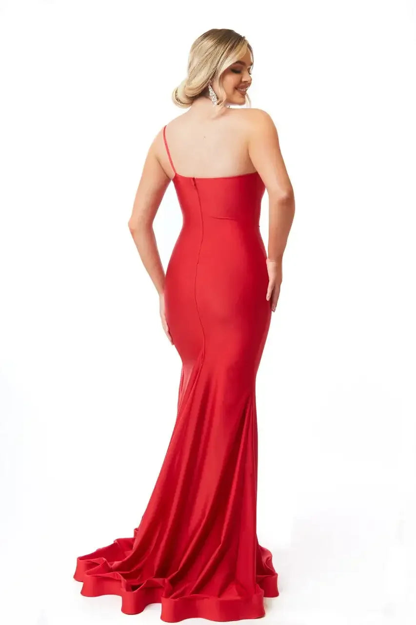 A woman wears a form-fitting red dress with a long train, facing away from the viewer. The background is plain white, highlighting the elegance of the dress.