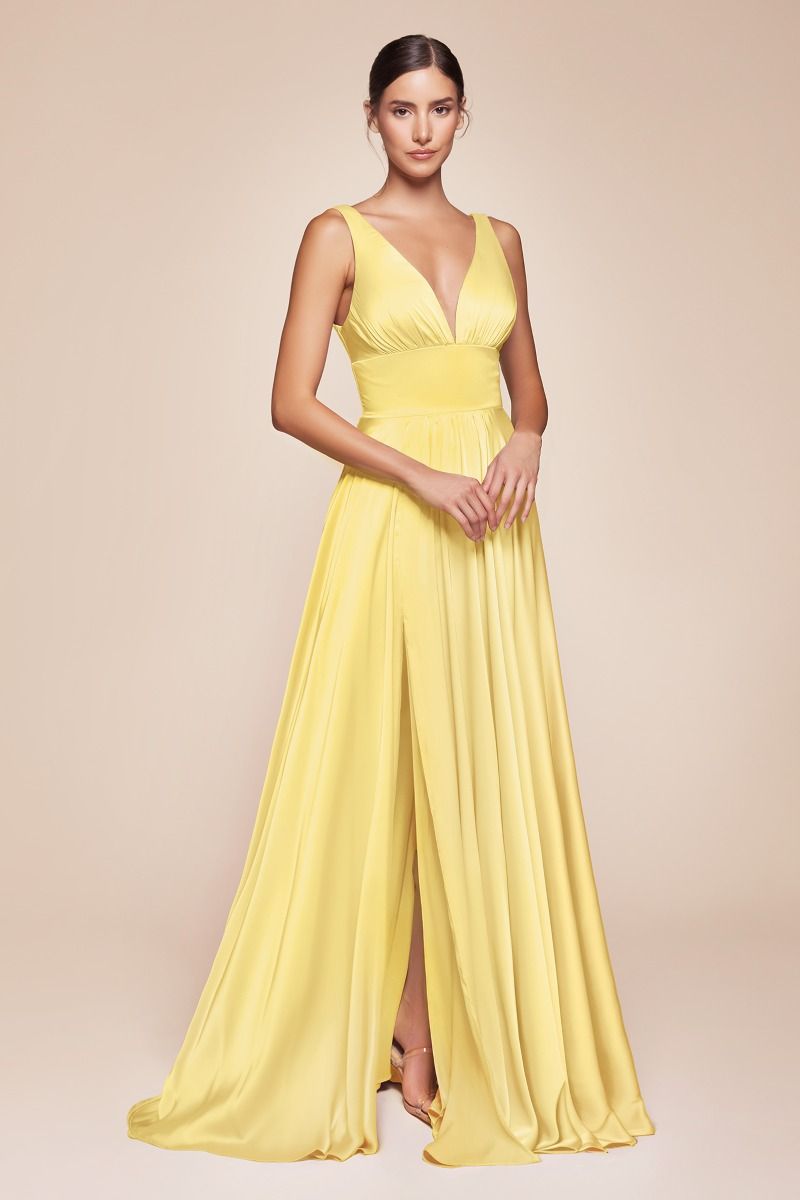 Woman wearing a yellow evening gown on a beige background