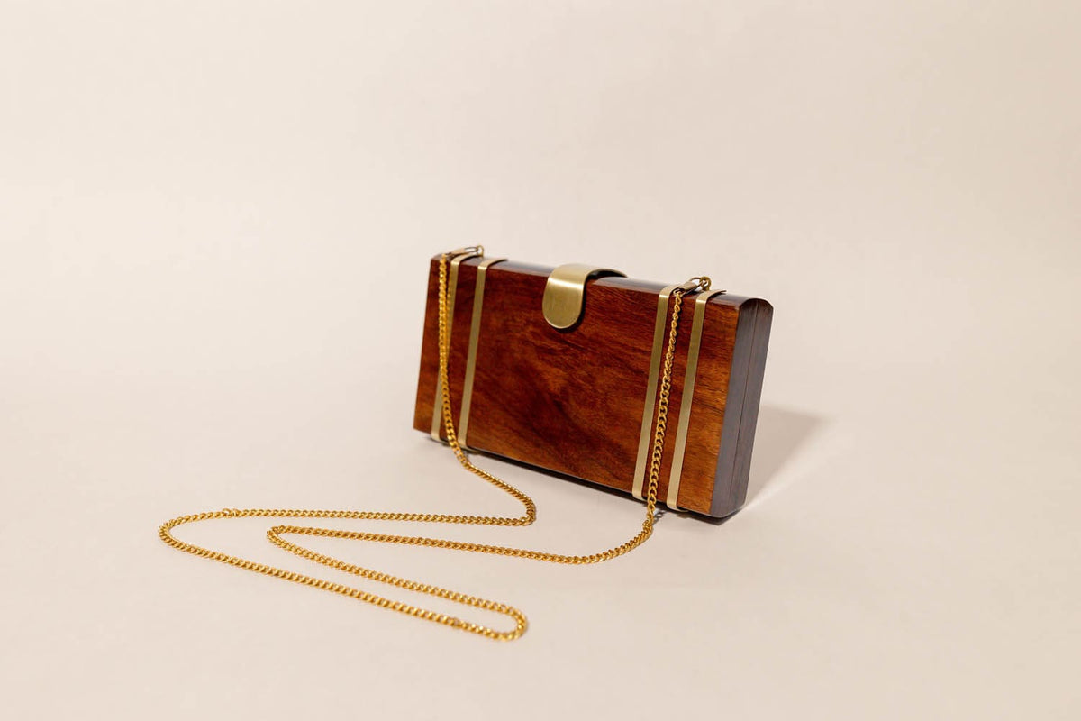 Wooden clutch bag with gold chain on a beige background