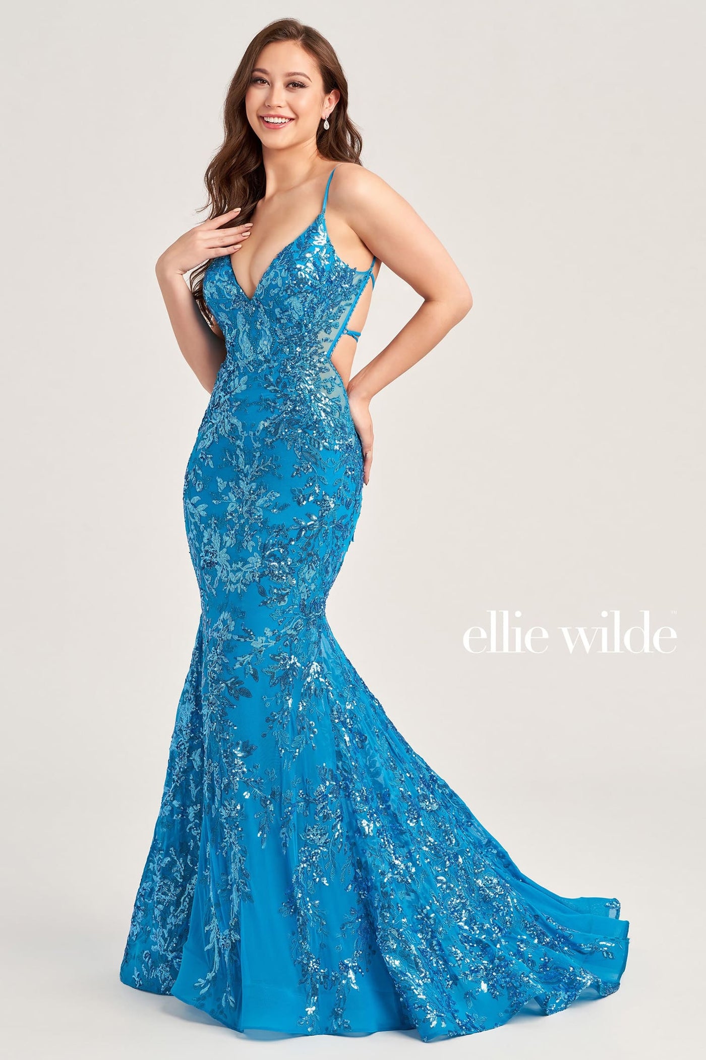 Woman wearing a blue evening gown with 'ellie wilde' branding on a white background