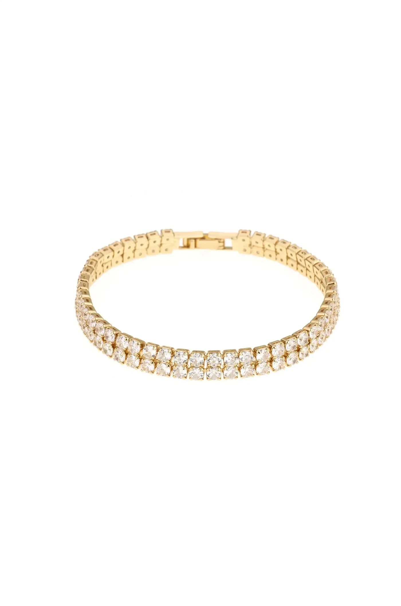 A gold bracelet adorned with sparkling clear gems, designed to fit snugly around a wrist, is showcased against a plain white background, emphasizing its elegance and shine.