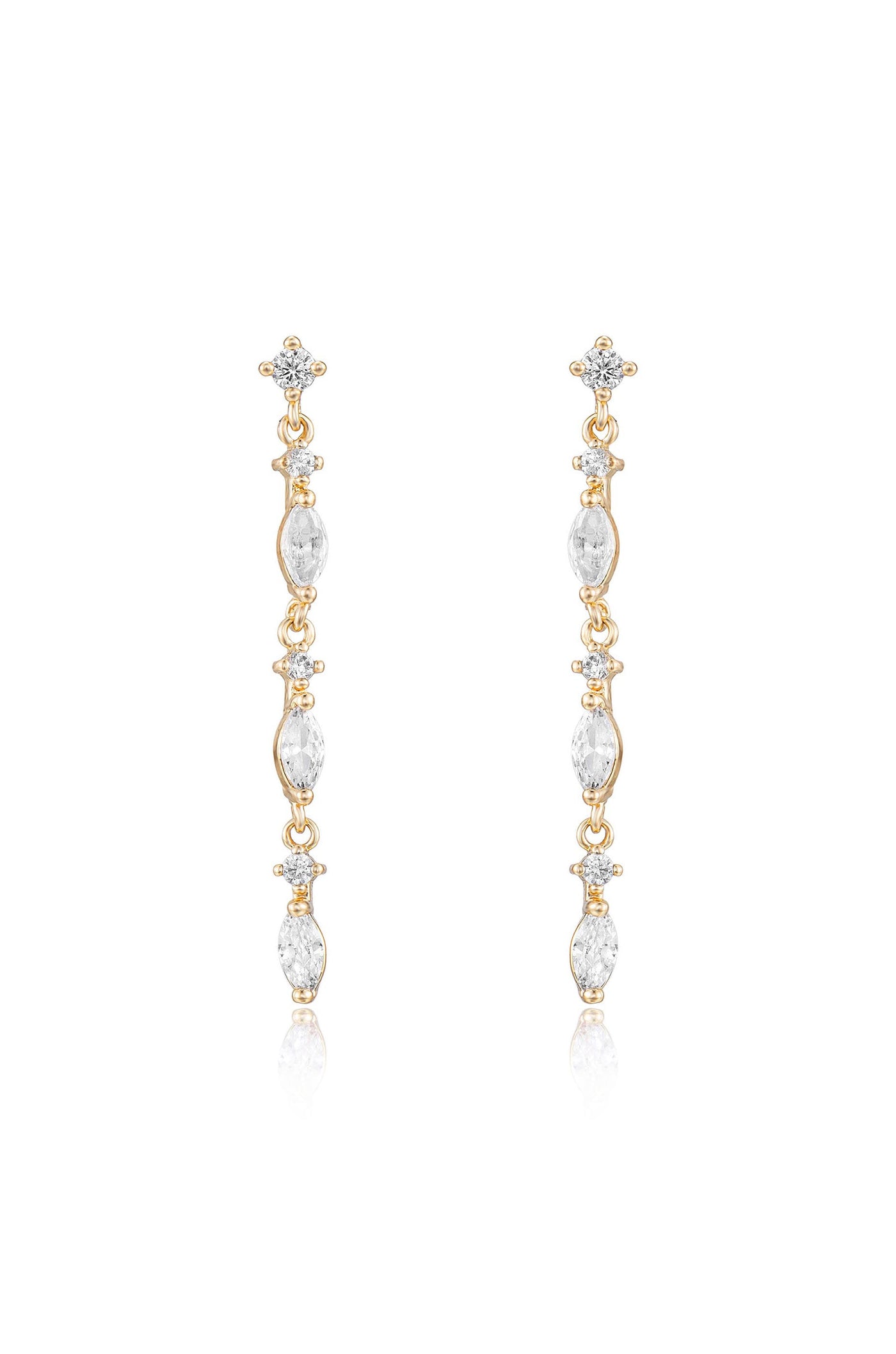 Long, elegant gold earrings feature a series of clear, sparkling gemstones arranged vertically. They hang gracefully, reflecting light, set against a plain, bright background.