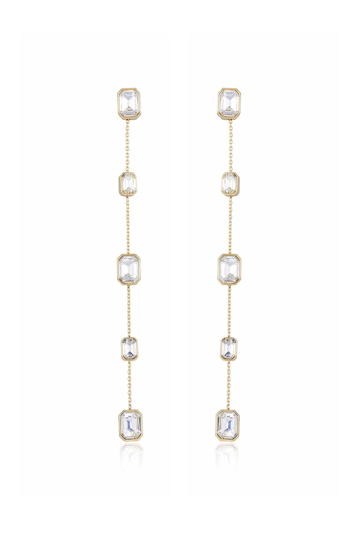 Gold dangle earrings feature multiple clear octagonal crystals linked by delicate chains, showcasing elegance and shine. They stand against a neutral background, highlighting their refined design and sparkle.