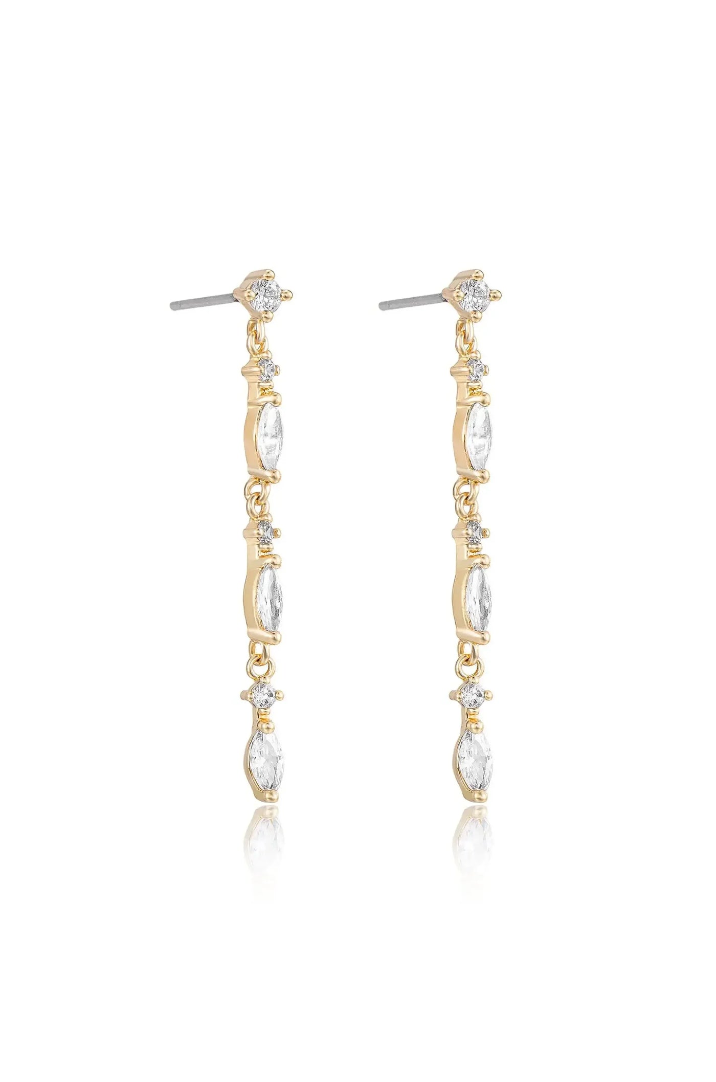 Dangle earrings are showcased, featuring elongated gold links adorned with clear gemstones. They are positioned against a light backdrop, reflecting a subtle shine.
