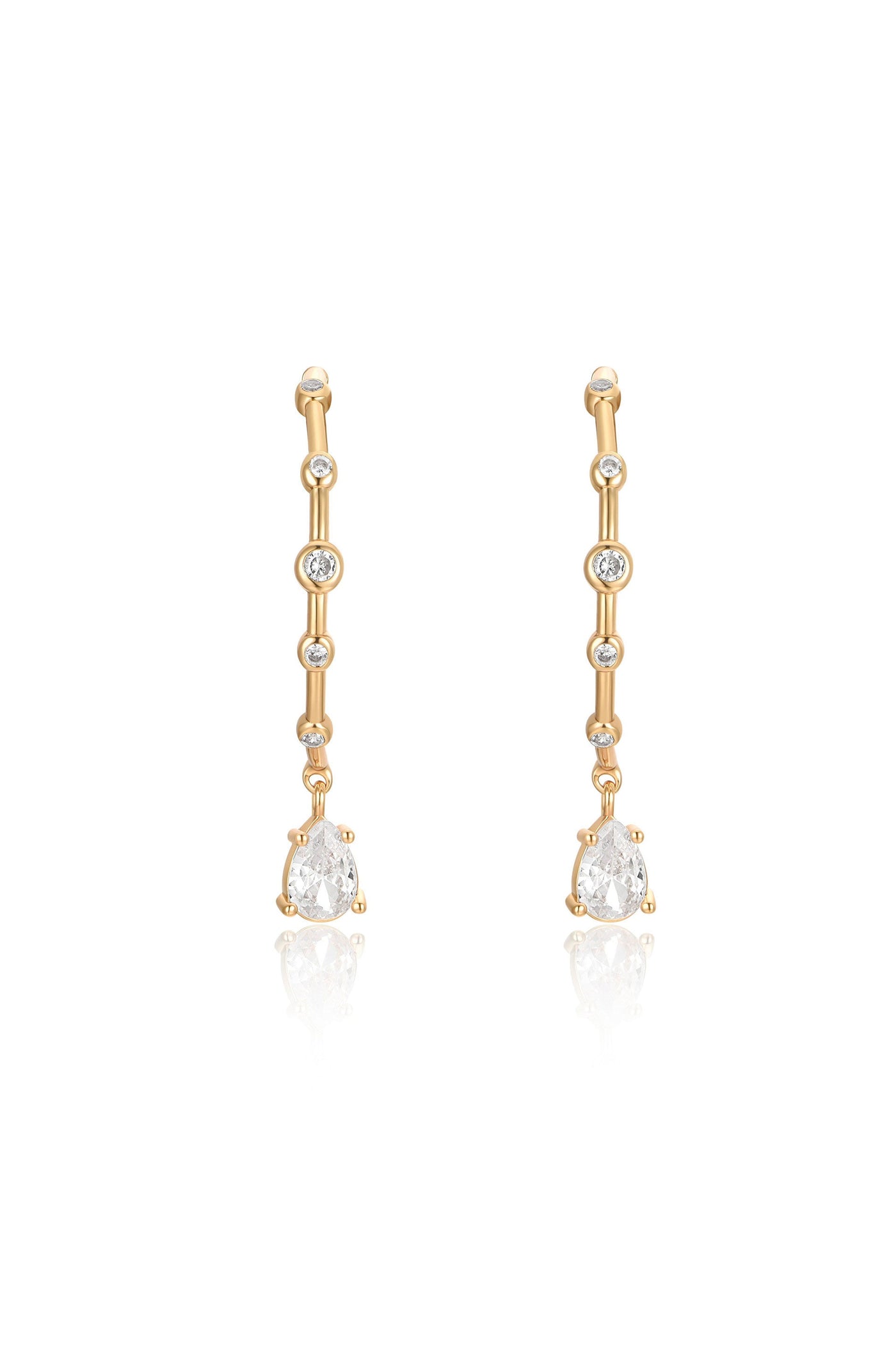 Gold drop earrings featuring multiple small diamonds along the length, with a larger pear-shaped diamond dangling at the bottom, set against a reflective surface.