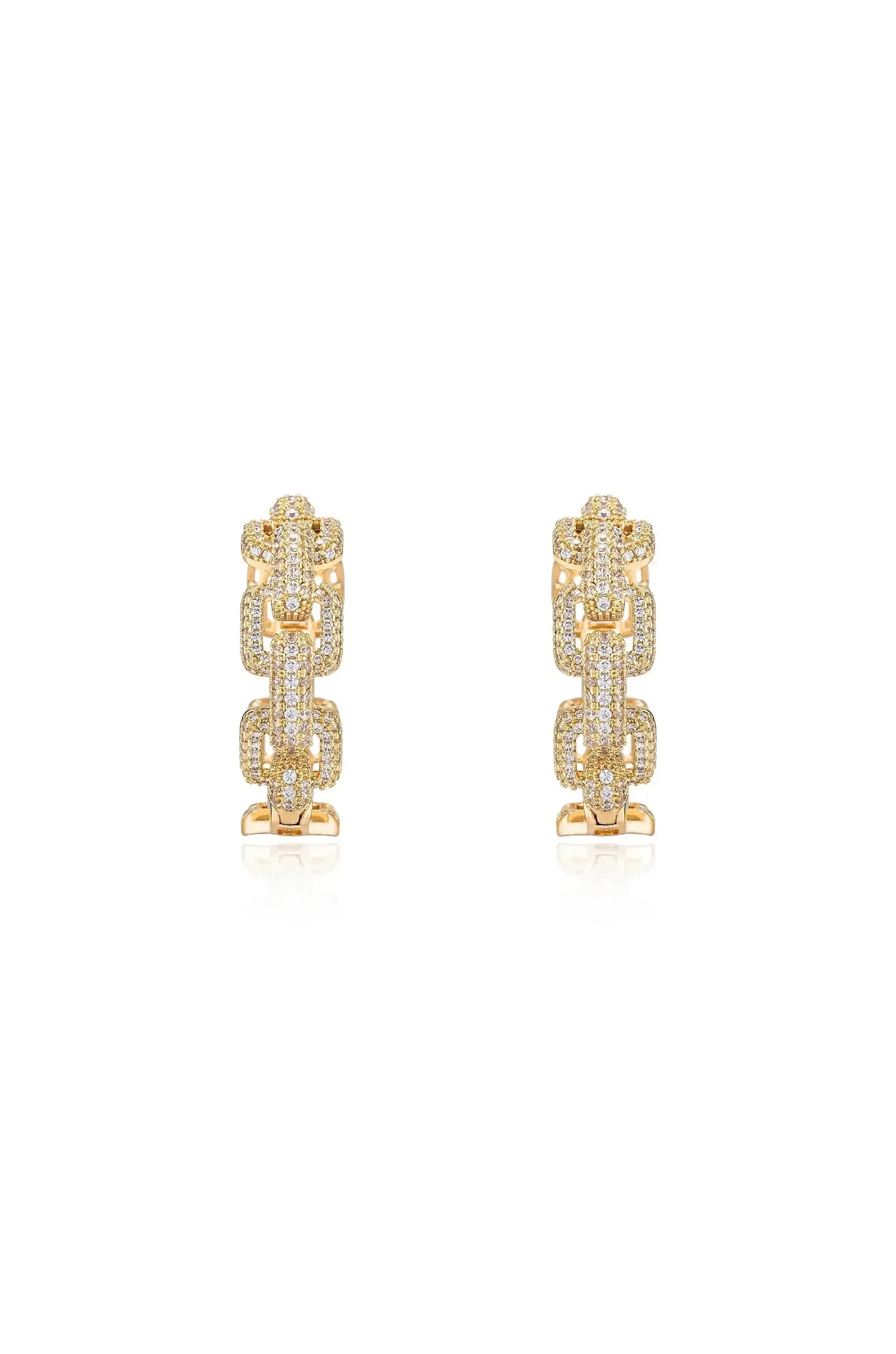 Gold earrings featuring intricate chain-like designs, adorned with sparkling gemstones. They are positioned symmetrically on a reflective surface against a plain white background, enhancing their shine and elegance.