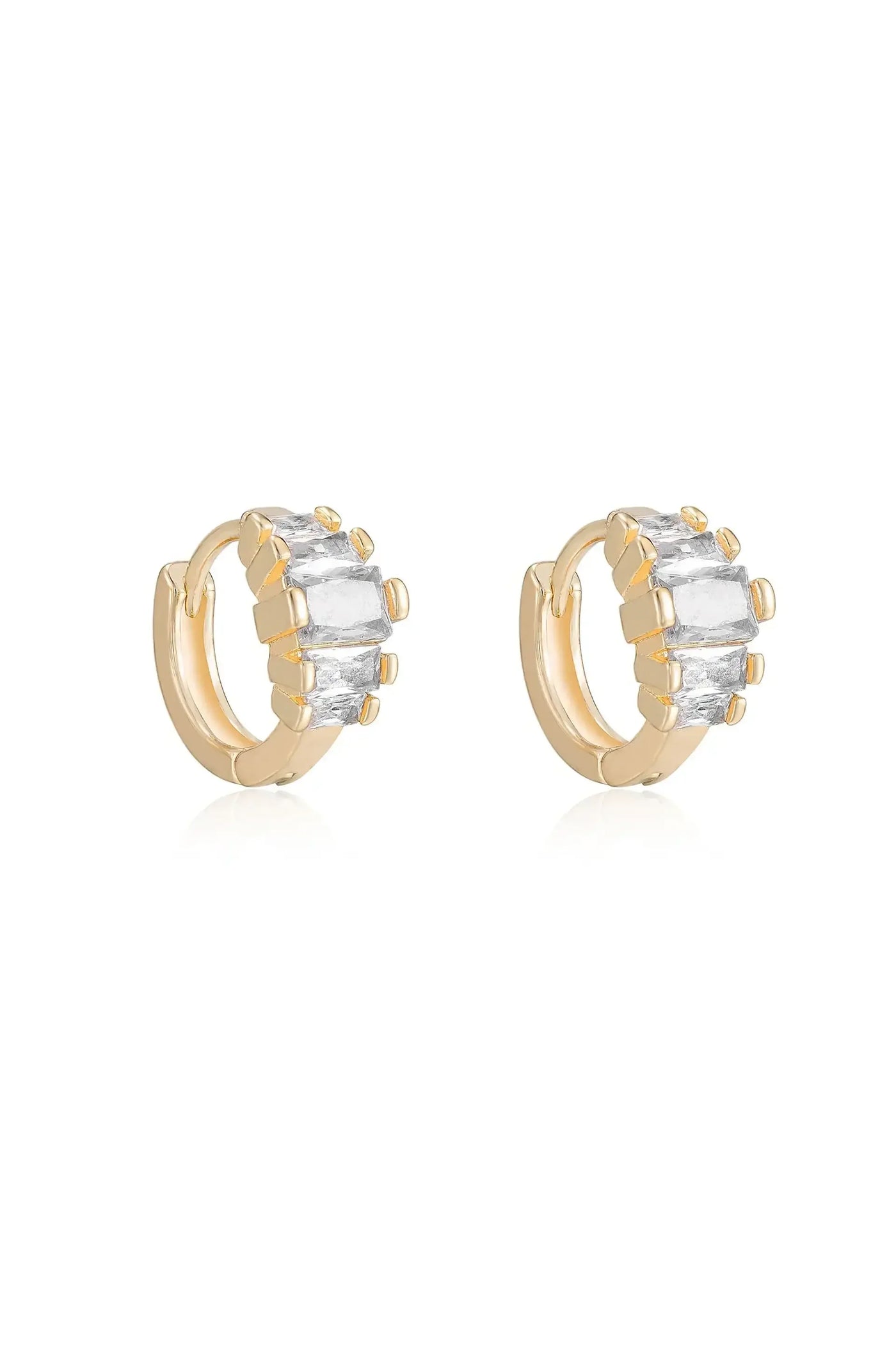 Two gold hoop earrings are displayed, each adorned with multiple rectangular and round gemstones. They sit on a reflective surface against a plain white background, emphasizing their design and shine.