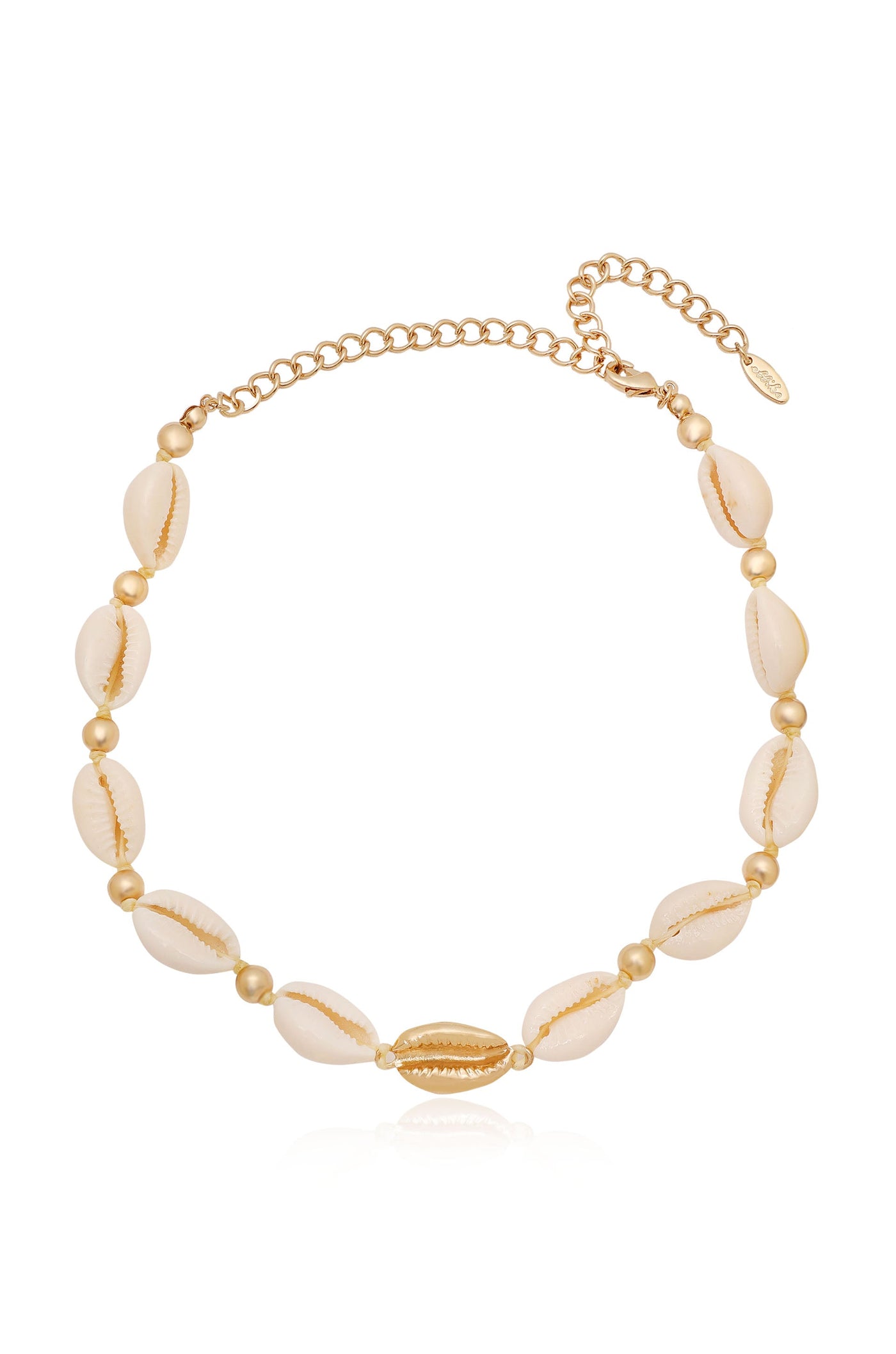 A necklace made of golden beads and cowrie shells, showcasing a combination of natural textures and metallic shine, rests against a light background, emphasizing its elegance and beach-inspired design.
