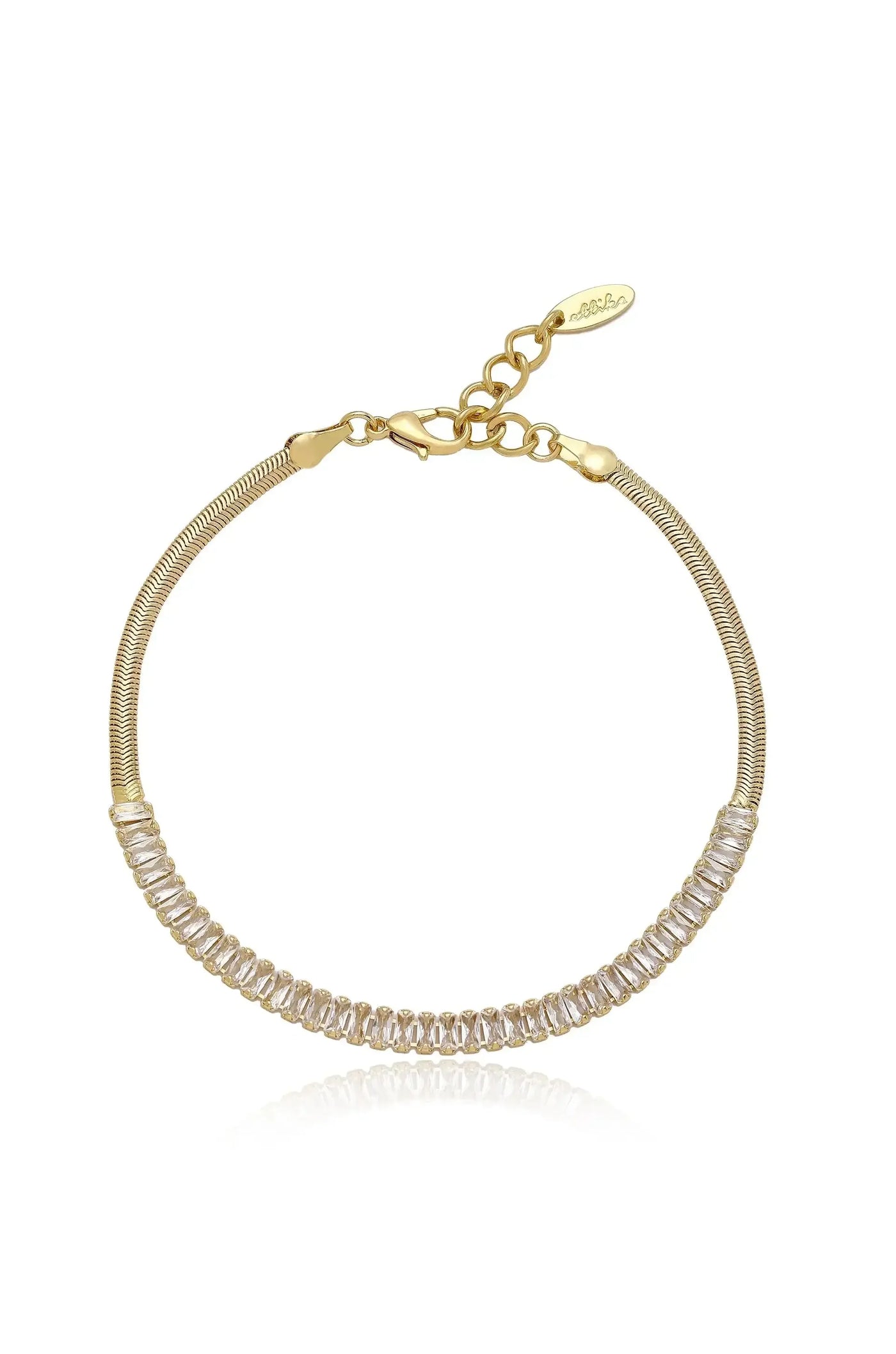 A gold bracelet features a flexible band with a row of clear, rectangular stones. It is presented against a reflective surface, enhancing its elegance and shimmer.