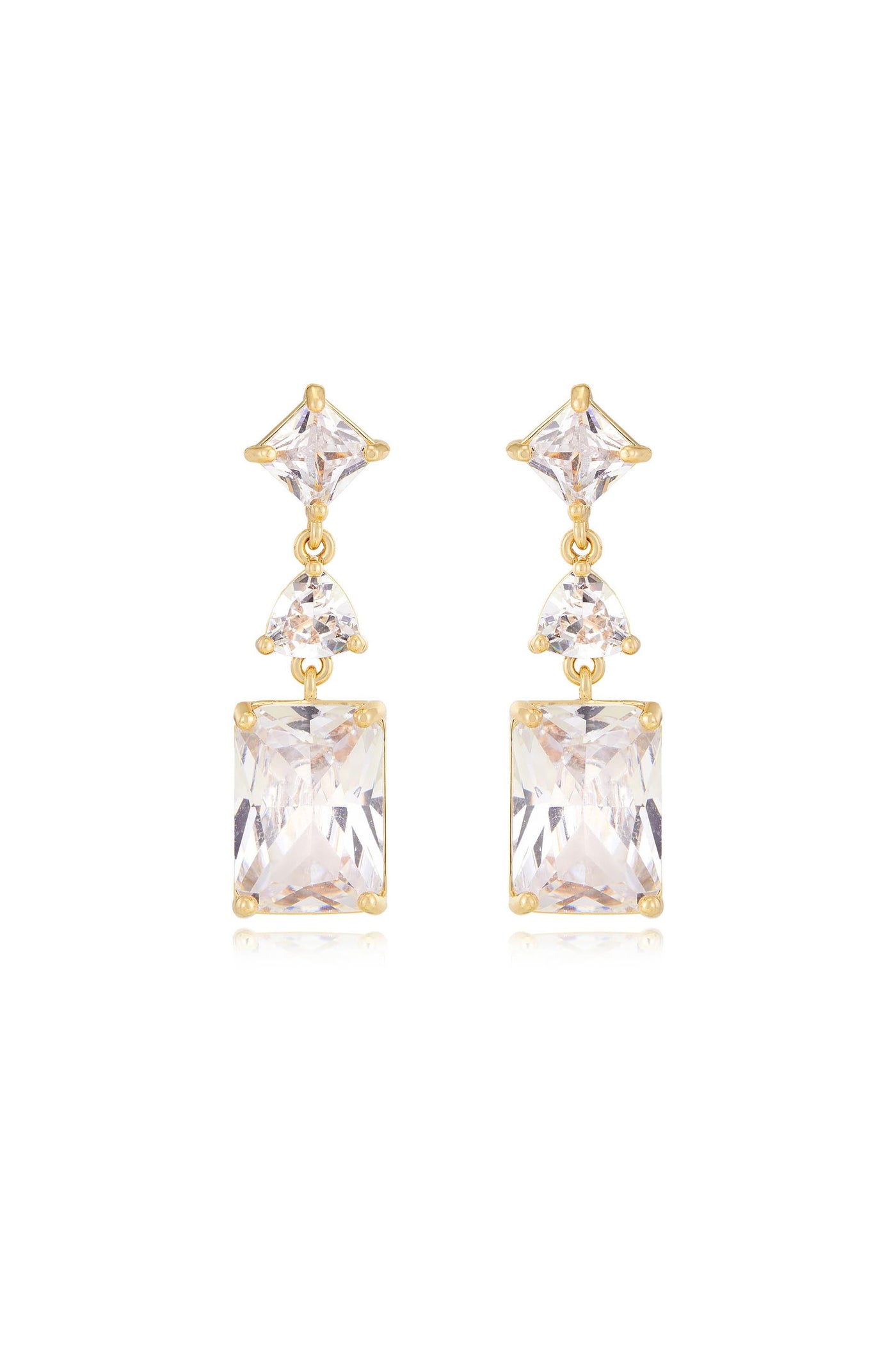 Gold earrings featuring a symmetrical design comprise an upper triangular gemstone, a smaller round gemstone, and a larger rectangular gemstone, reflecting light against a neutral background.