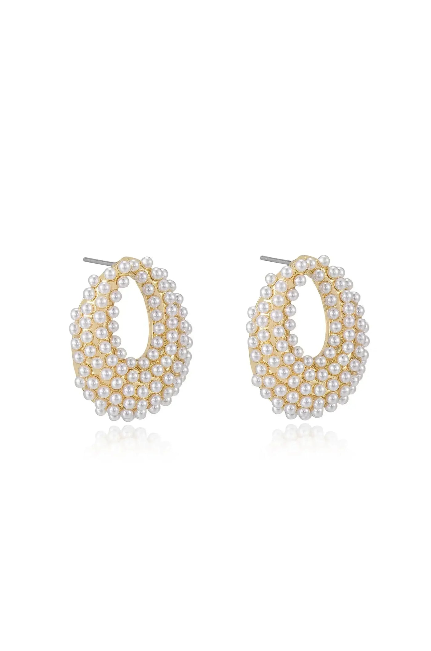 Gold-tone hoop earrings adorned with multiple small pearls, arranged in an oval shape, resting elegantly on a reflective surface, creating a sophisticated and chic appearance.