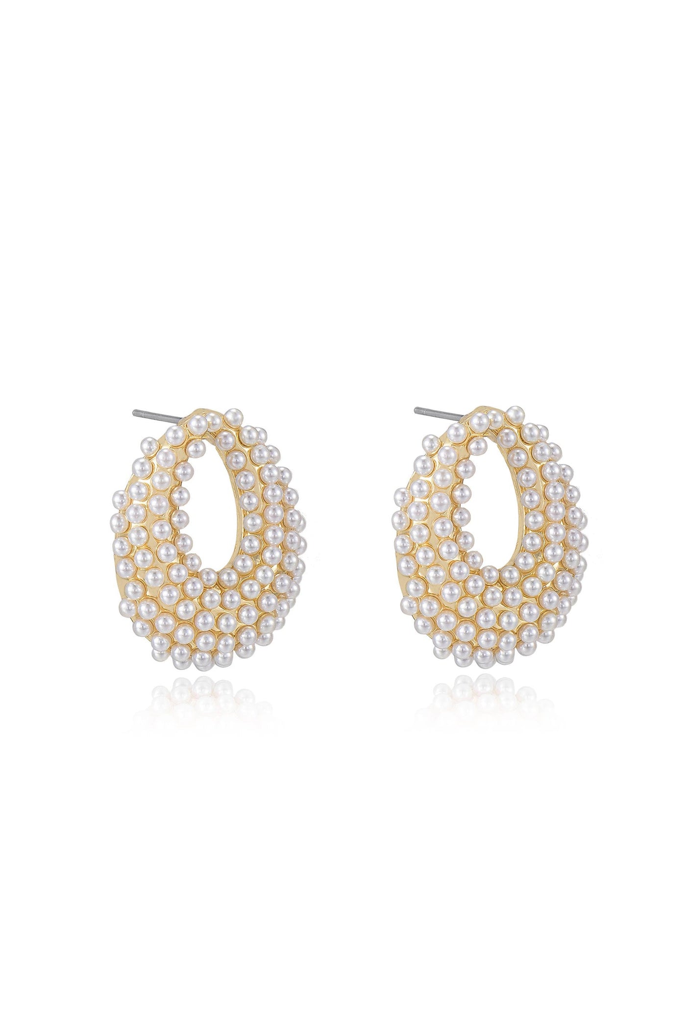 Gold-tone hoop earrings adorned with multiple small pearls, arranged in an oval shape, resting elegantly on a reflective surface, creating a sophisticated and chic appearance.
