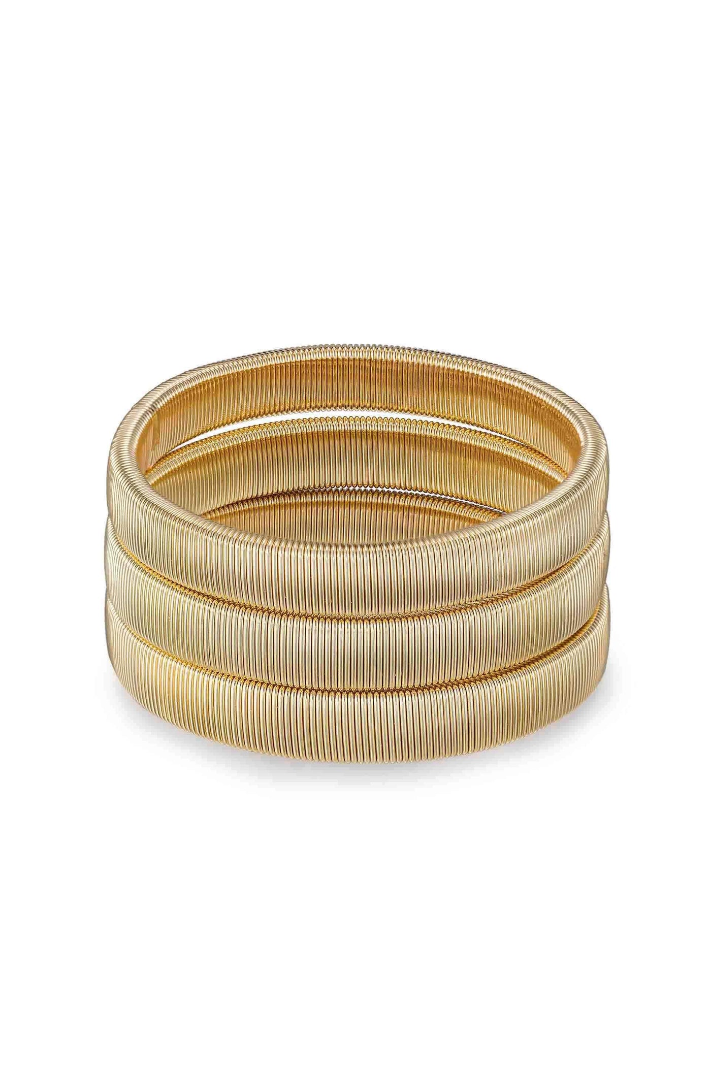 Three intertwined golden bangles sit stacked on a clean, white surface, showcasing their smooth, coiled design, reflecting light to highlight their metallic sheen.