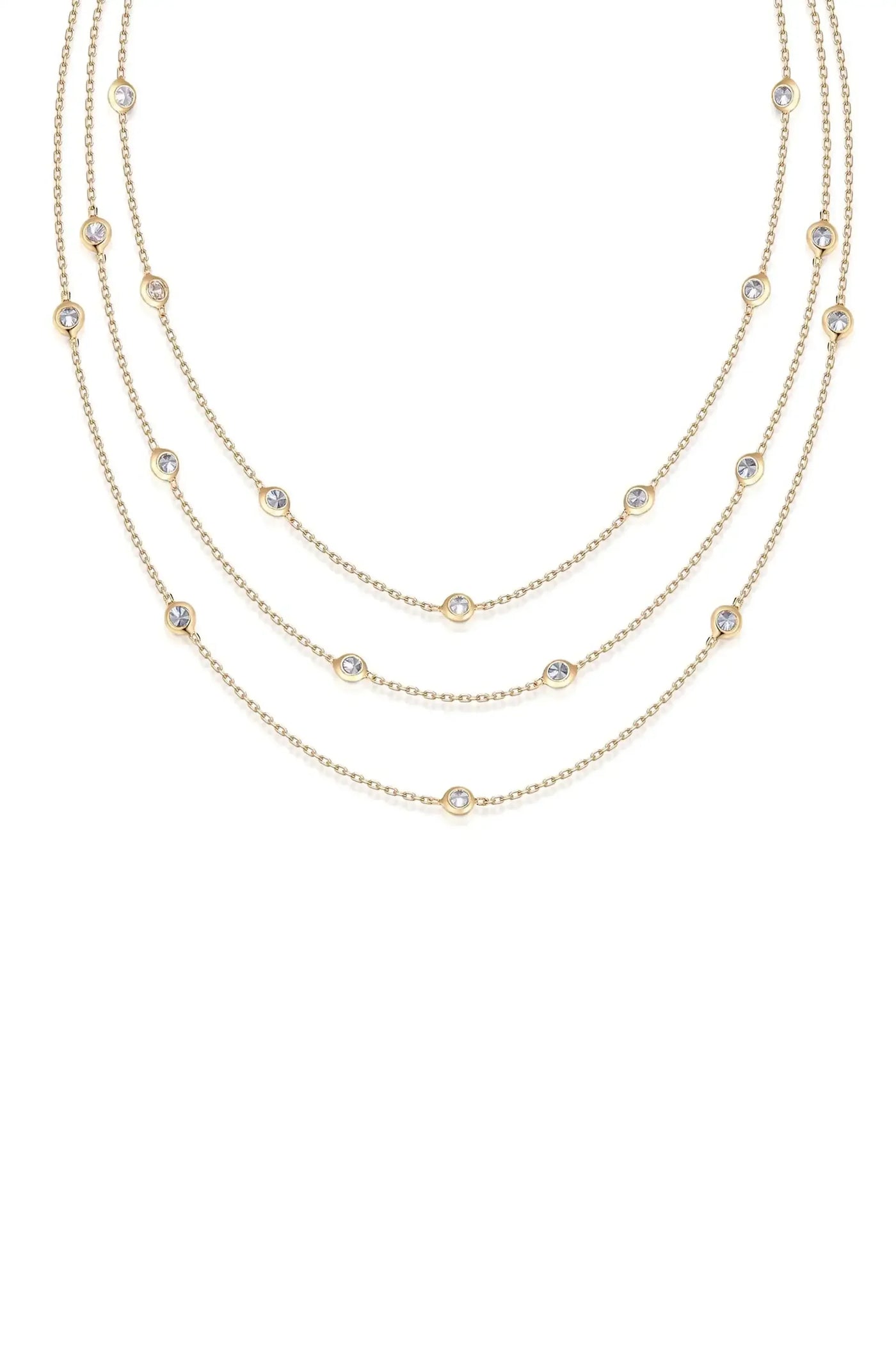 A layered gold necklace adorned with evenly spaced, circular gems rests against a plain white background, highlighting its elegant design and shimmering details.