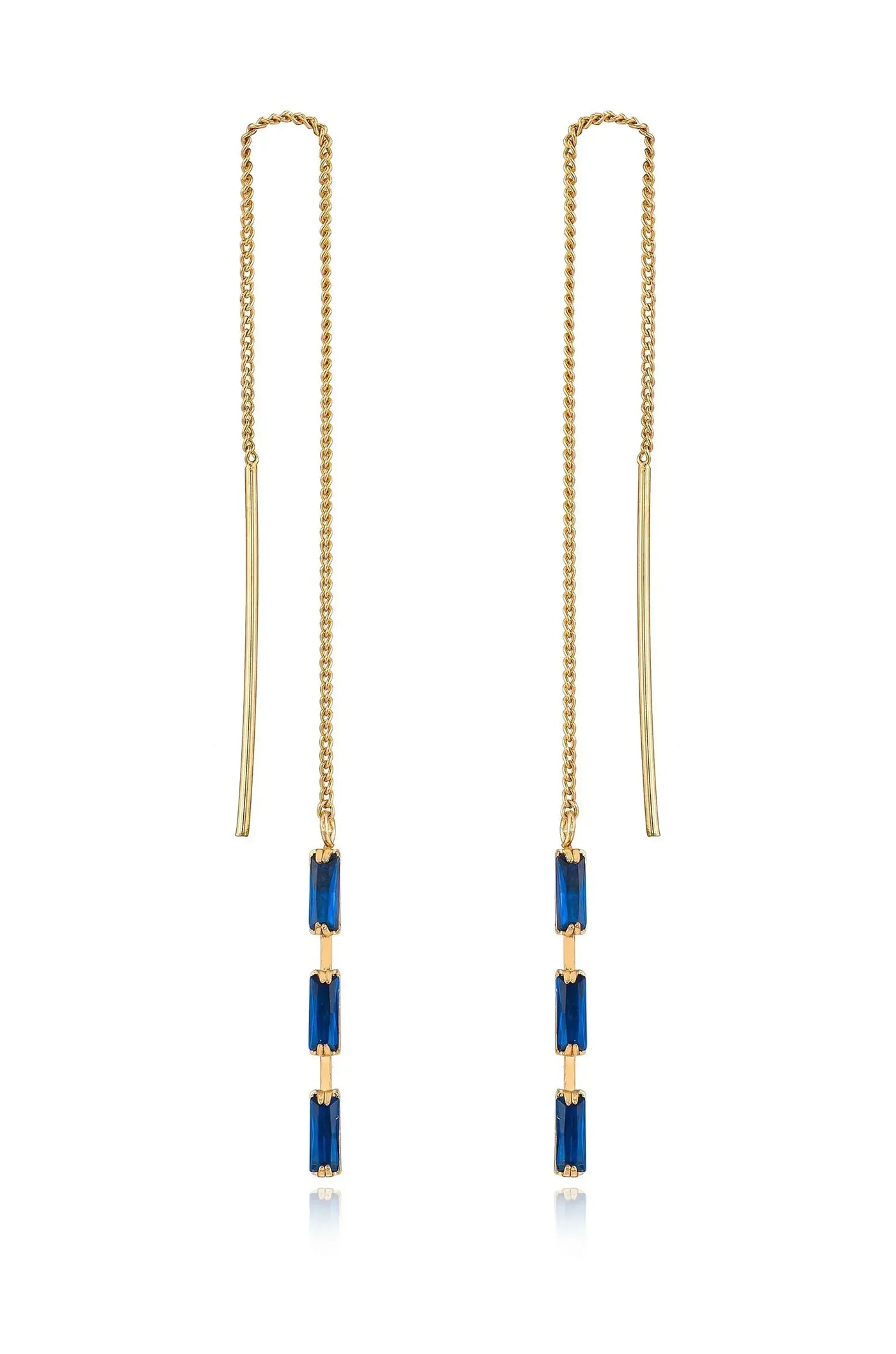 Earrings with a delicate gold chain feature three rectangular blue gemstones arranged vertically. The earrings hang elegantly, reflecting light against a neutral background.