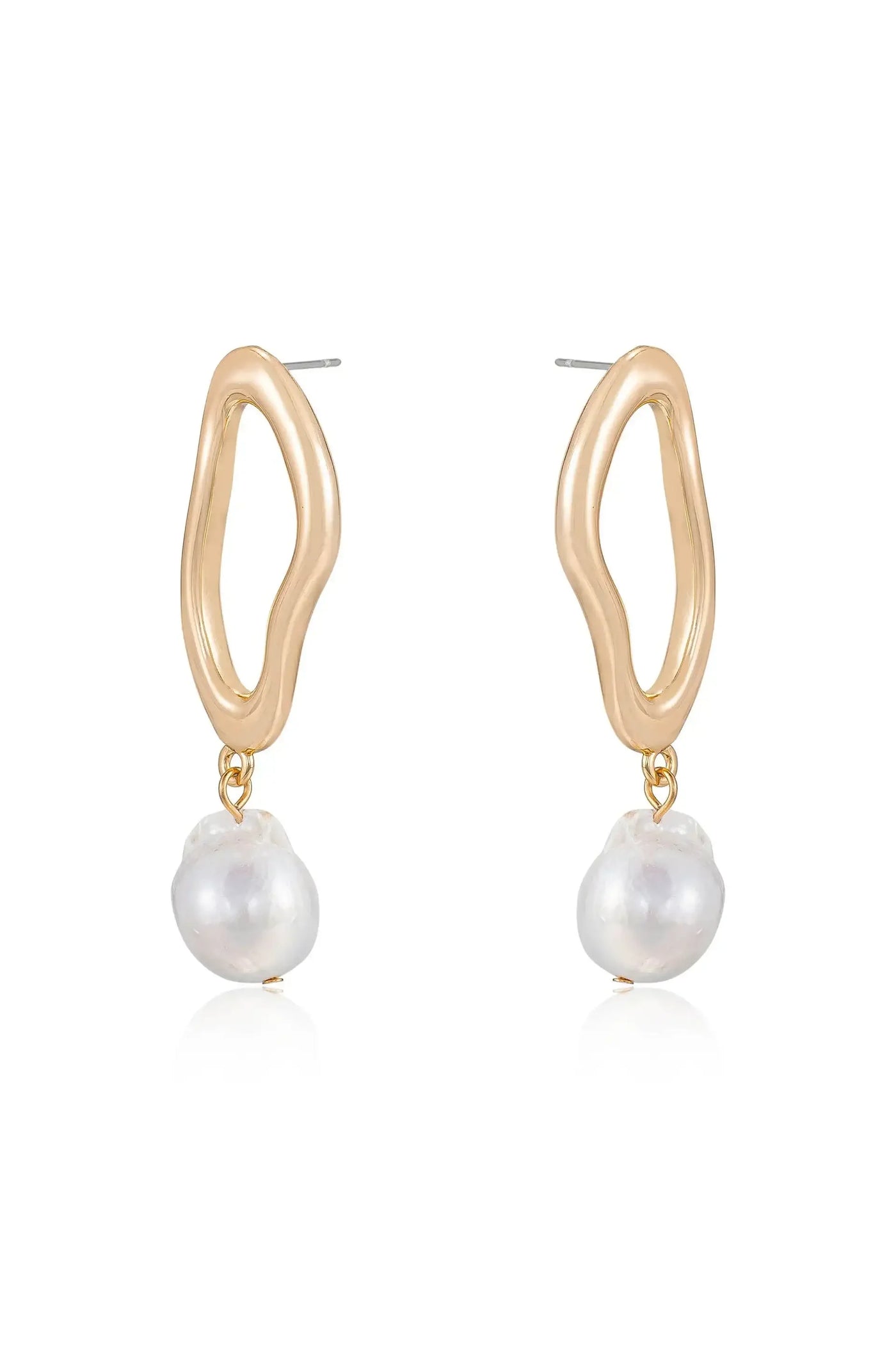 Gold hoop earrings feature an organic, wavy design with a dangling irregularly shaped white pearl. They are displayed against a simple, reflective background, emphasizing their elegance.