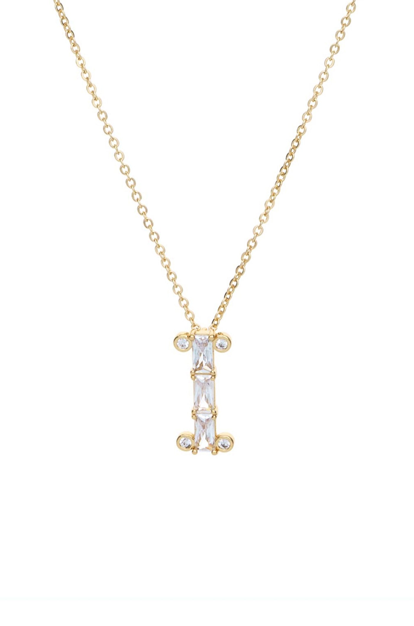 A gold necklace features a vertical pendant in the shape of the letter “I,†adorned with five clear gemstones arranged in a line, against a plain white background.