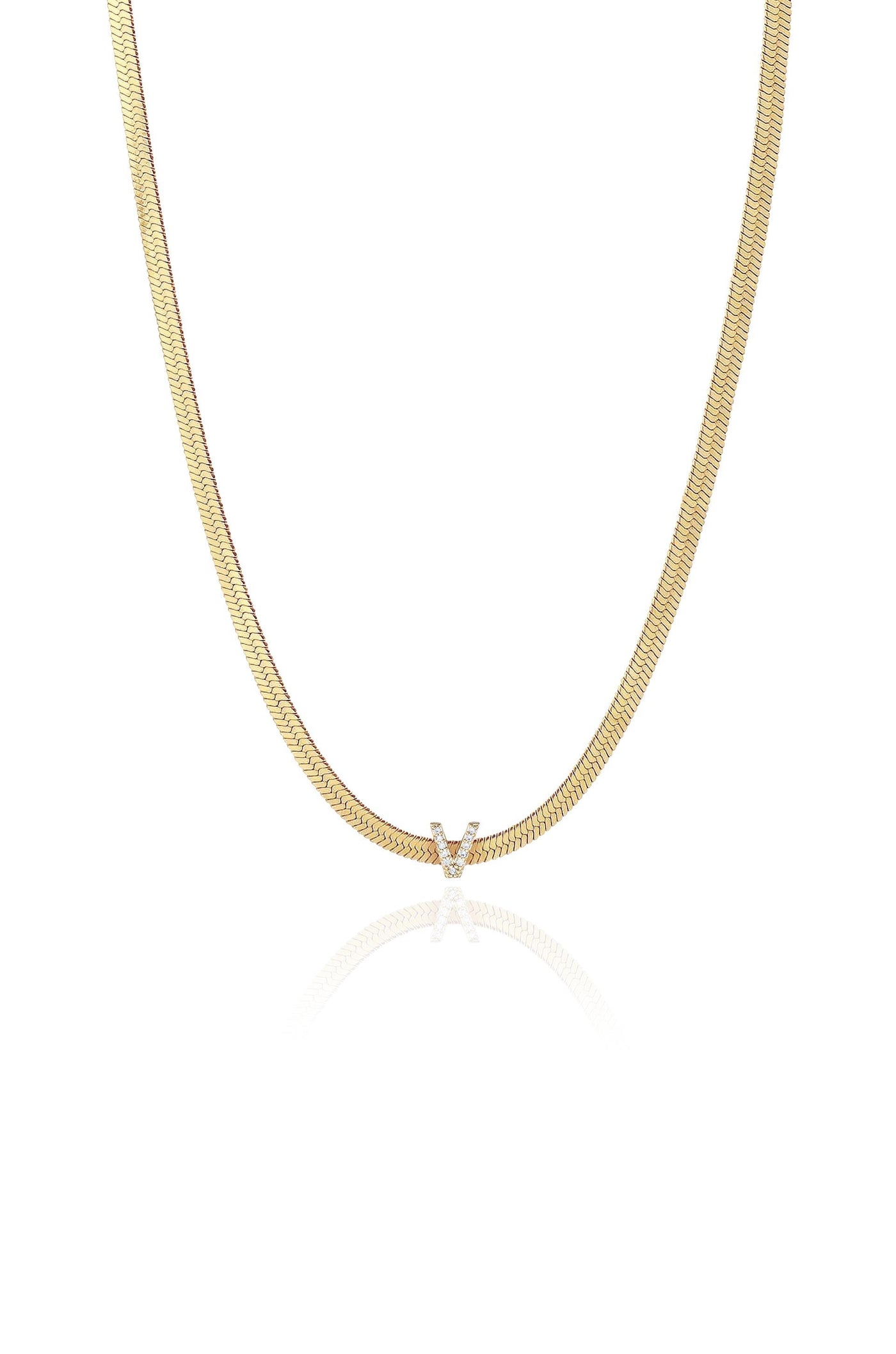 A polished gold necklace with a subtle herringbone pattern hangs in the center, featuring a diamond-encrusted "V" pendant, displayed against a white background that reflects its shine.