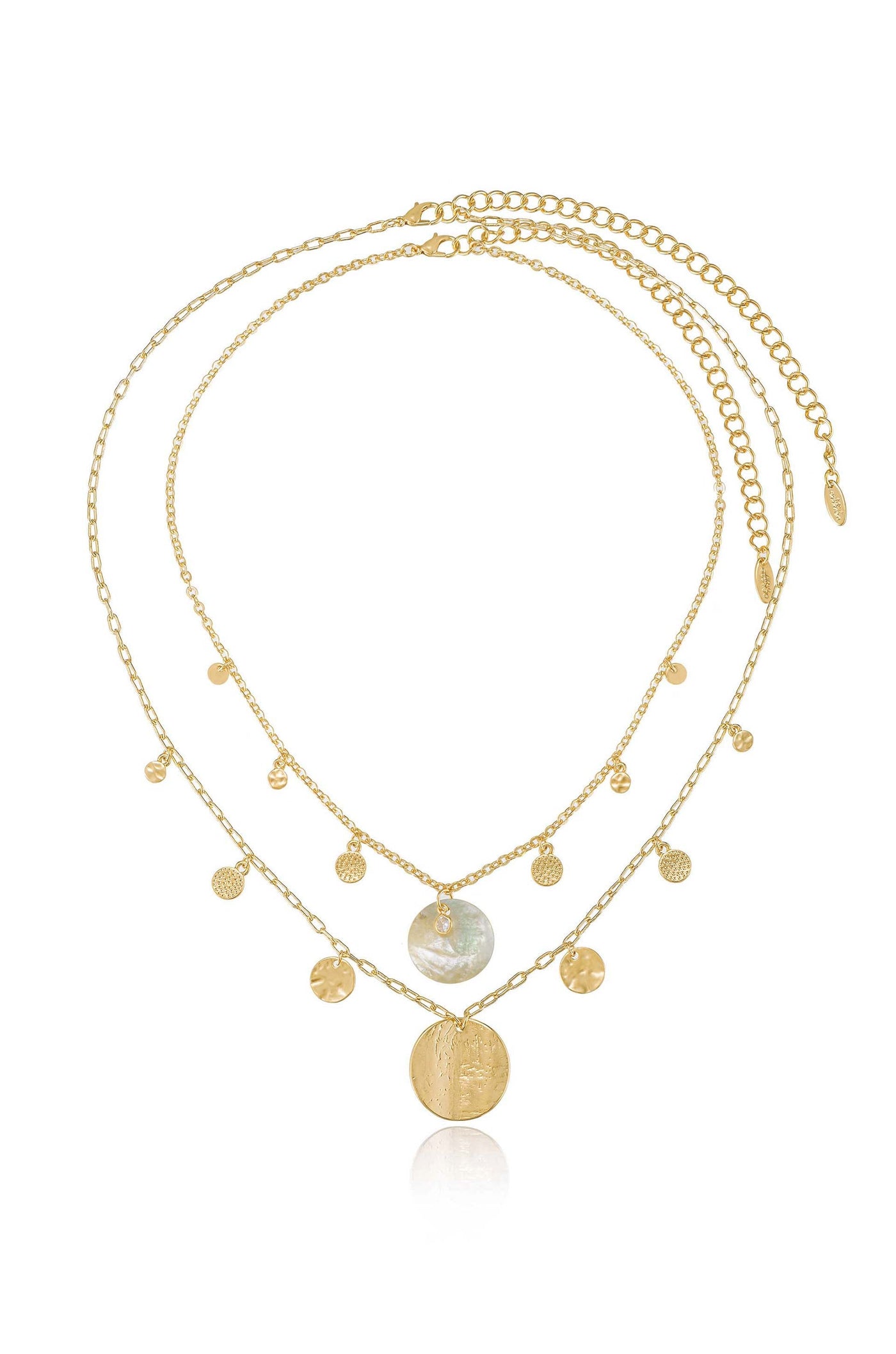 A layered gold necklace with delicate chains features a large iridescent pendant and smaller textured charms, elegantly resting on a reflective surface, showcasing its intricate design.