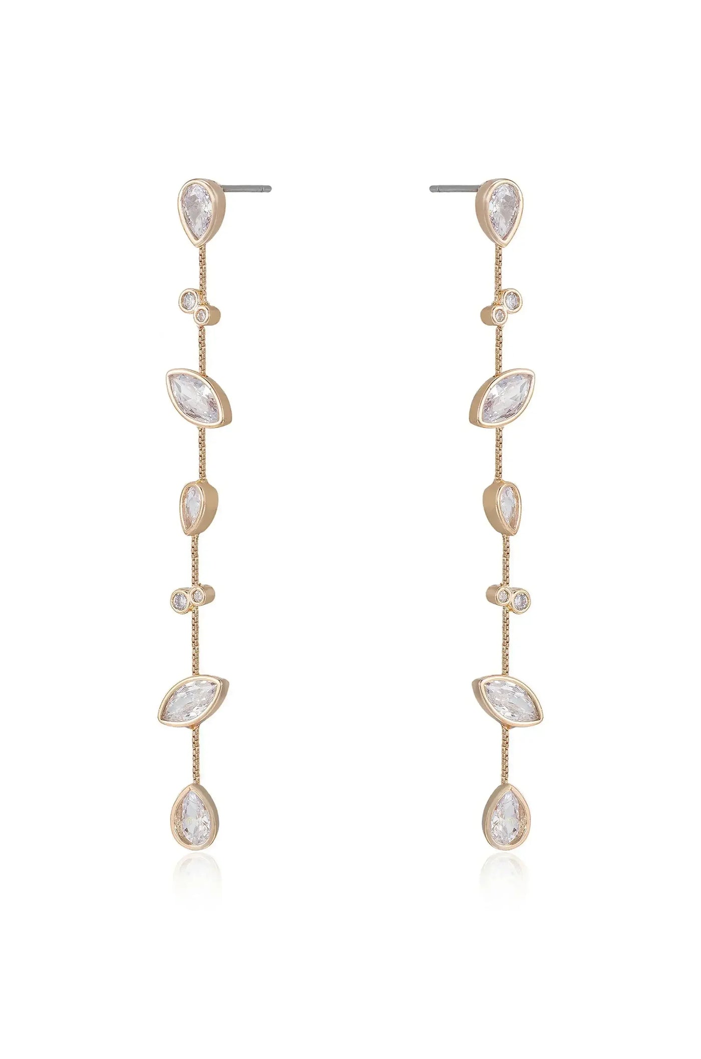 Long, elegant earrings made of gold feature a series of sparkling, teardrop-shaped gemstones cascading down a delicate chain. They shimmer against a soft, reflective surface.