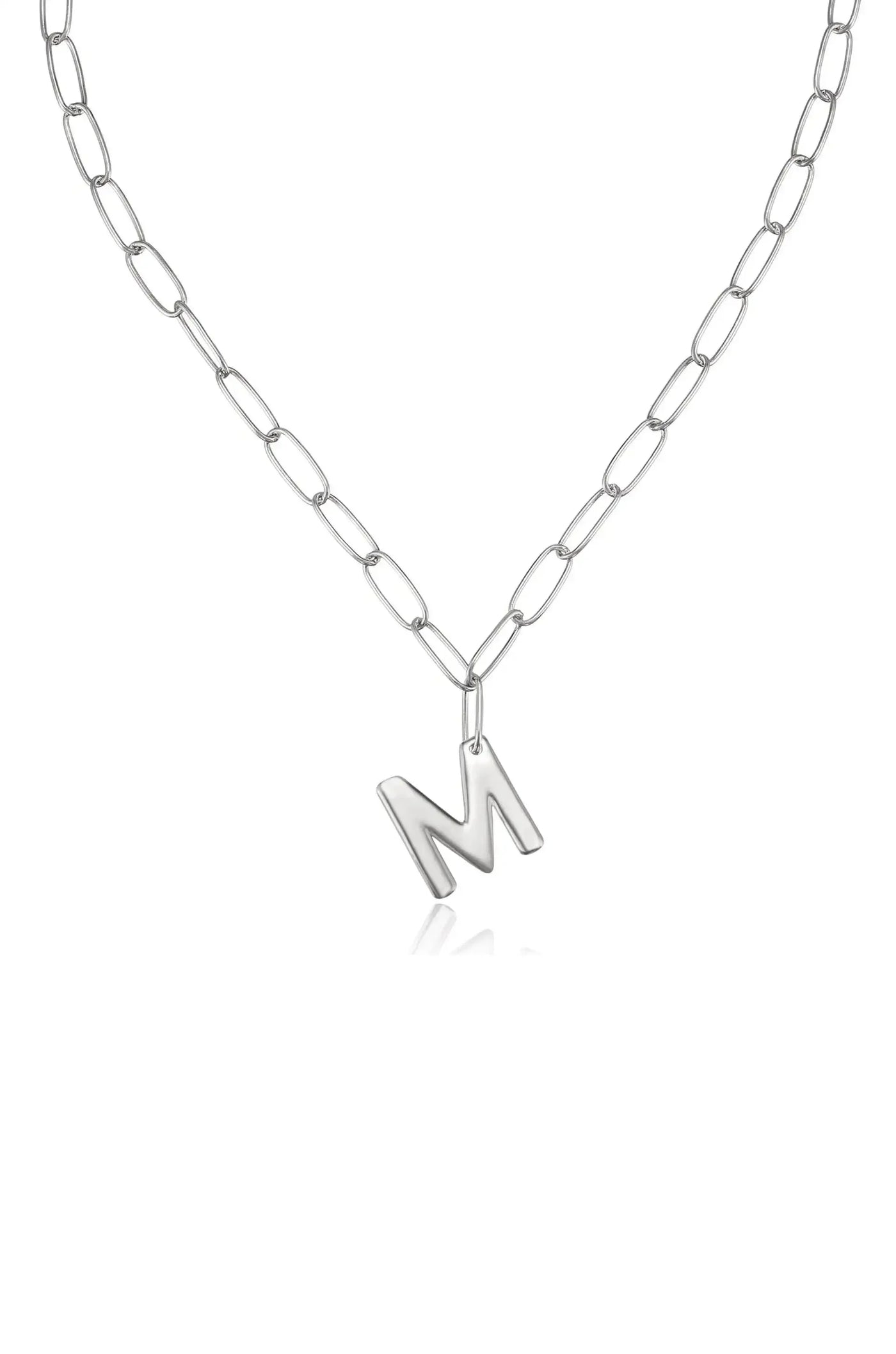 A silver chain necklace features a prominent letter "M" pendant, hanging centrally against a white background, emphasizing its contemporary design and personal touch.