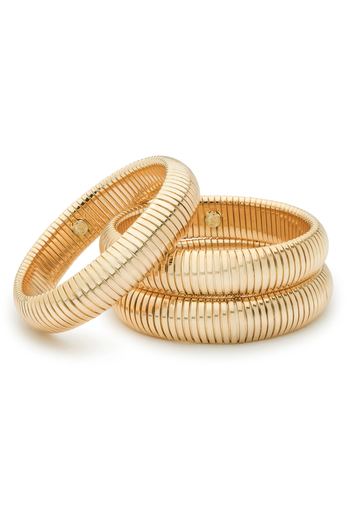 Three gold bangles are overlapping, showcasing their smooth, ribbed surfaces and reflective quality, set against a plain white background that highlights their elegant design.
