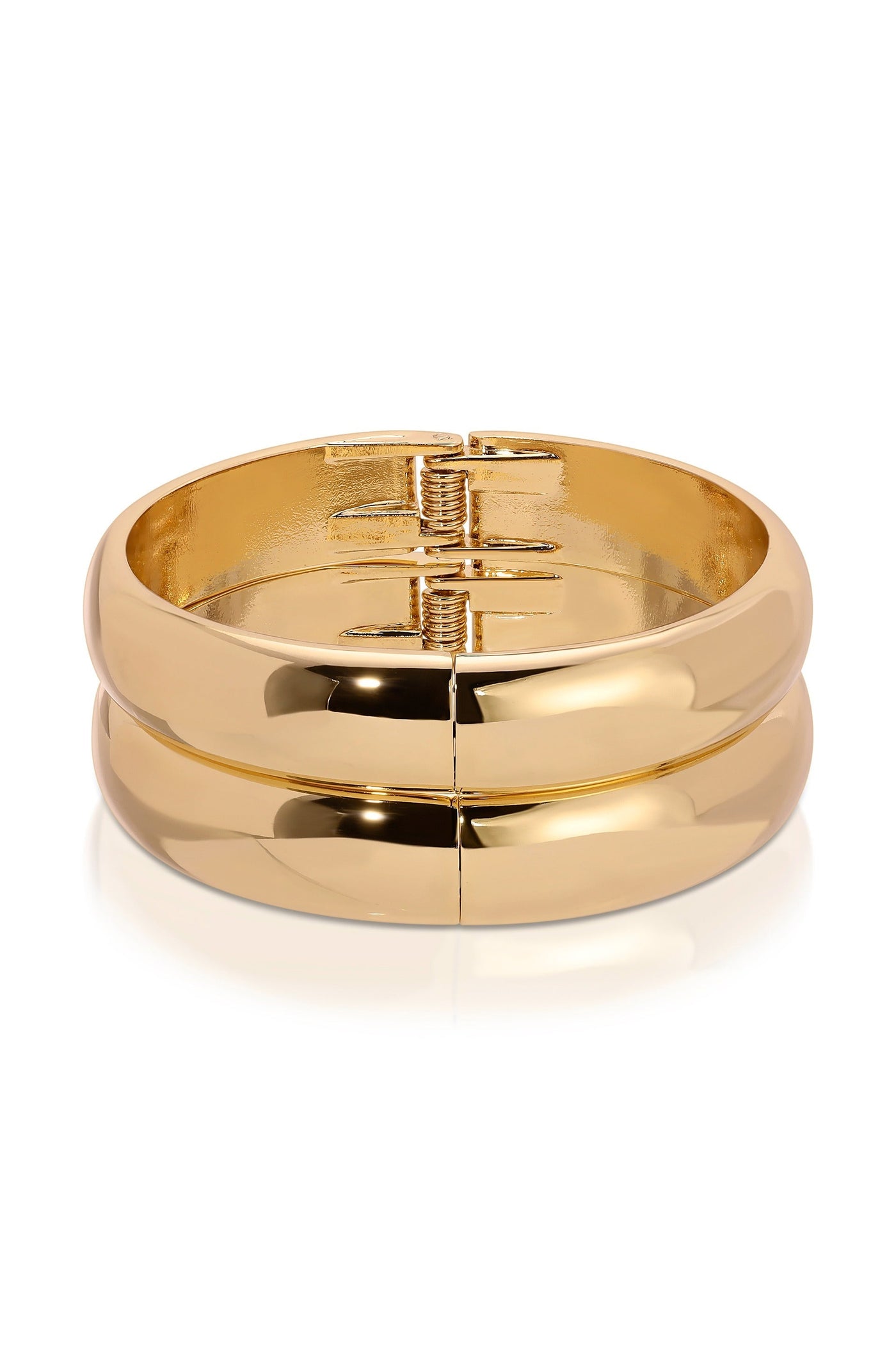 A gold bangle bracelet sits on a smooth surface, showcasing its shiny, reflective surface. The design features a hinge mechanism for easy opening and closing, emphasizing its sleek appearance.