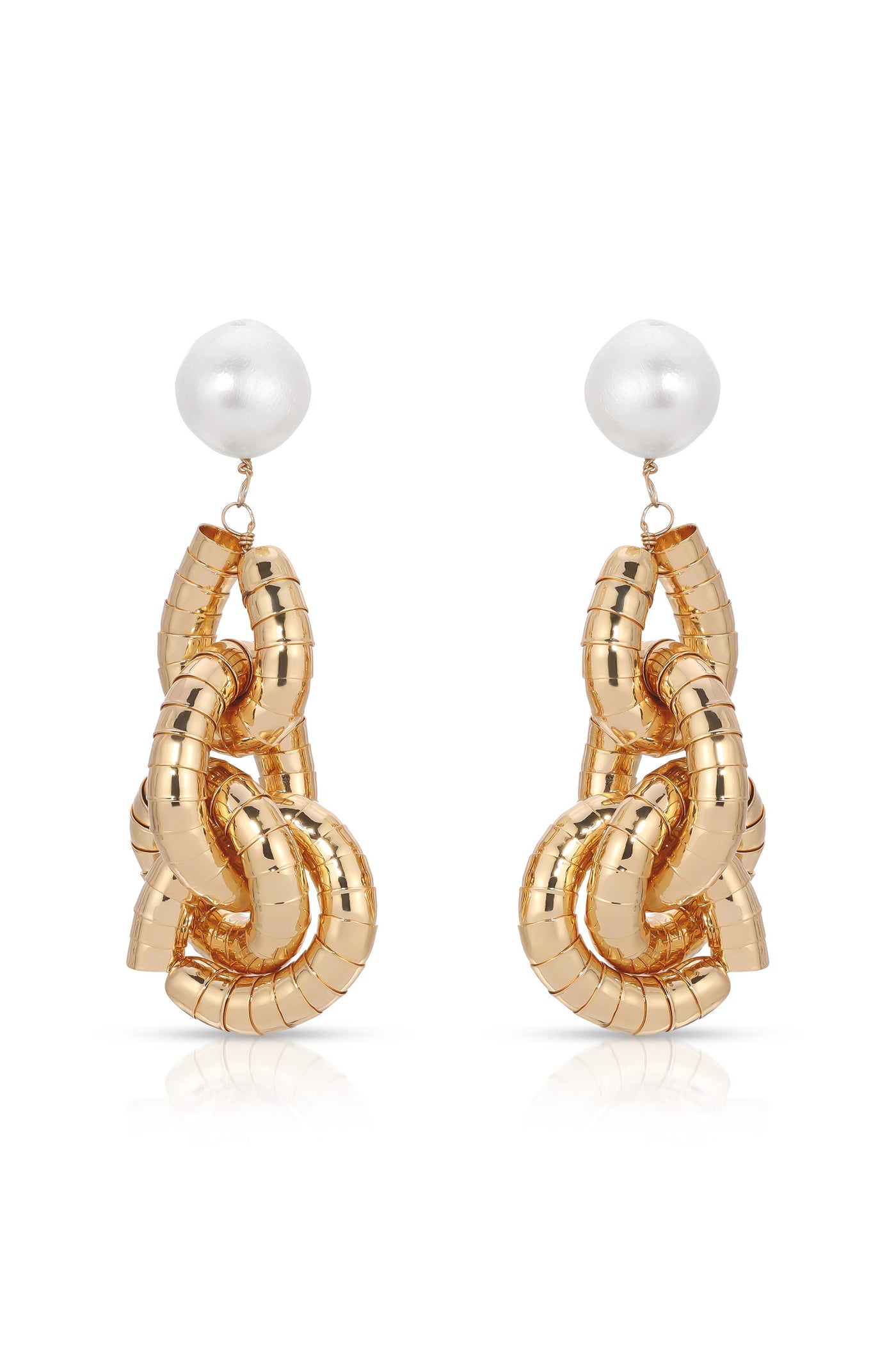 Two gold-colored earrings shaped like intertwined links feature a shiny white spherical bead at the top. They are displayed against a reflective background.