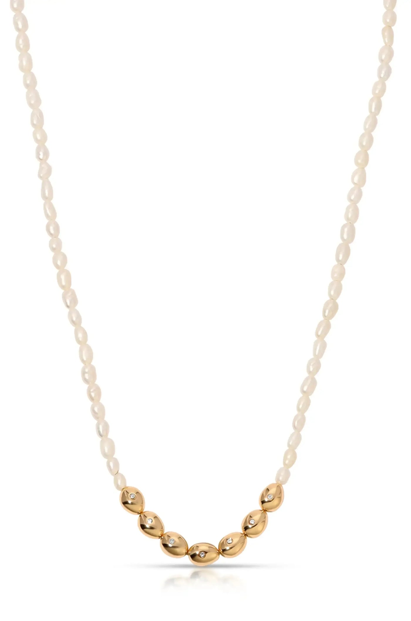 A pearl necklace combines small, glossy white pearls with larger gold oval-shaped beads, some adorned with sparkling stones, elegantly displayed against a plain background.