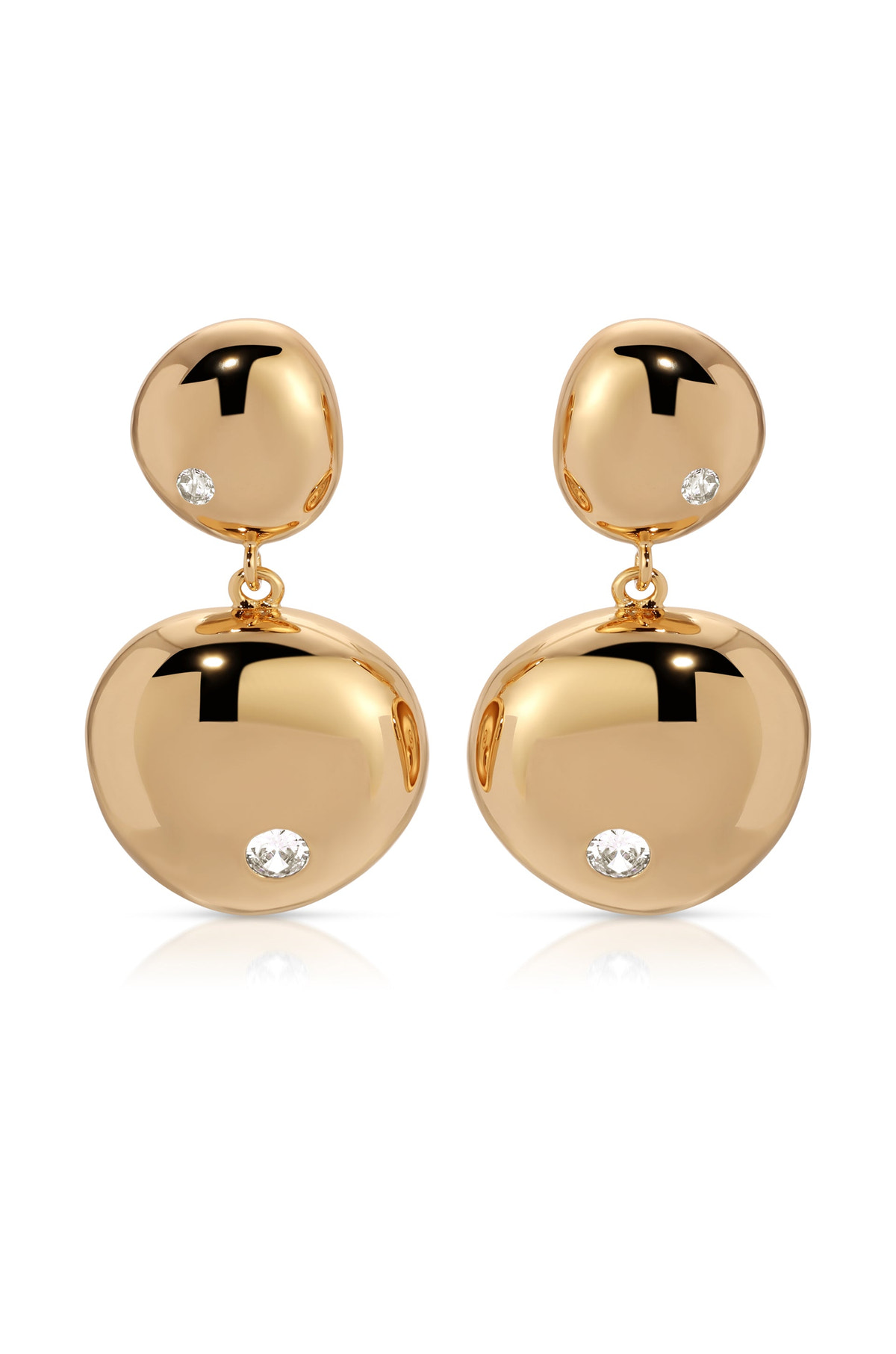 Two gold earrings dangle elegantly, featuring polished, rounded shapes adorned with small, sparkling diamonds. They rest on a white surface, reflecting light and enhancing their luxurious appearance.
