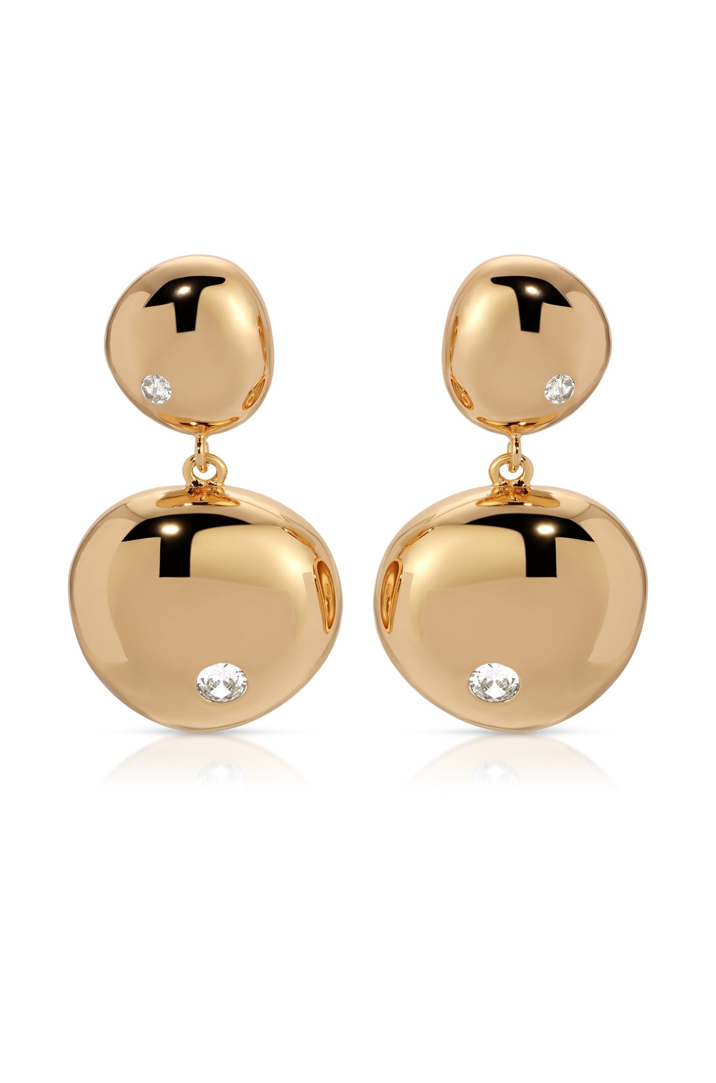 Two gold earrings dangle elegantly, featuring polished, rounded shapes adorned with small, sparkling diamonds. They rest on a white surface, reflecting light and enhancing their luxurious appearance.