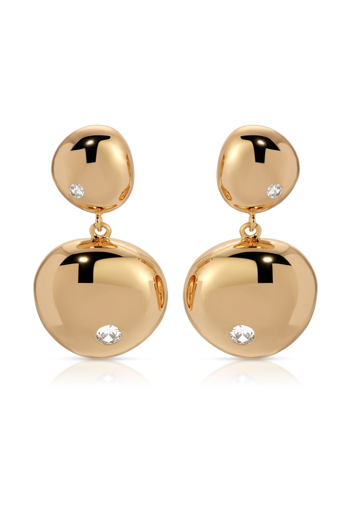 Two gold earrings dangle elegantly, featuring polished, rounded shapes adorned with small, sparkling diamonds. They rest on a white surface, reflecting light and enhancing their luxurious appearance.