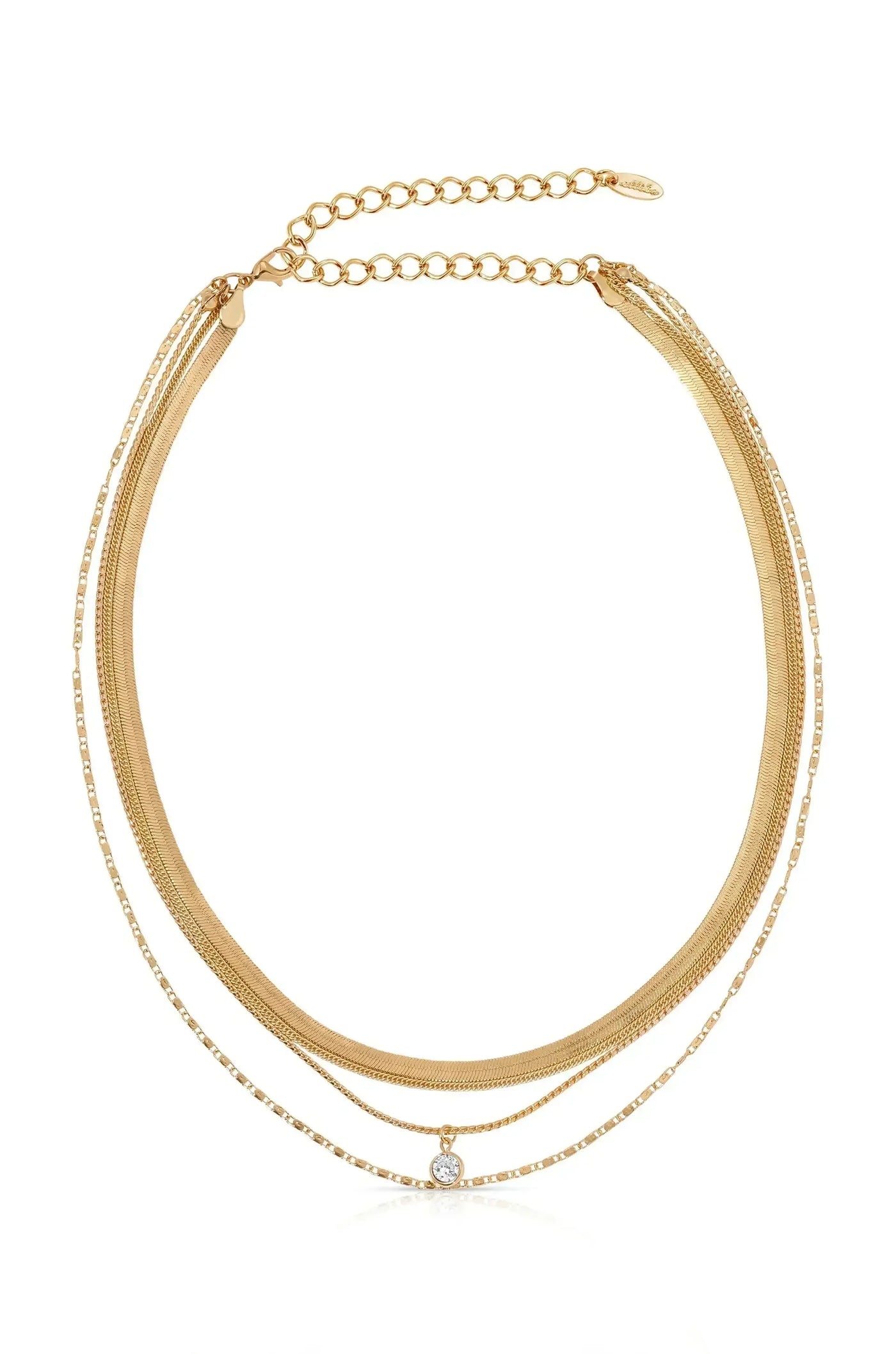 A layered gold necklace is displayed, featuring multiple chains of varying thicknesses, with a central pendant showcasing a sparkling gemstone, set against a simple white background.