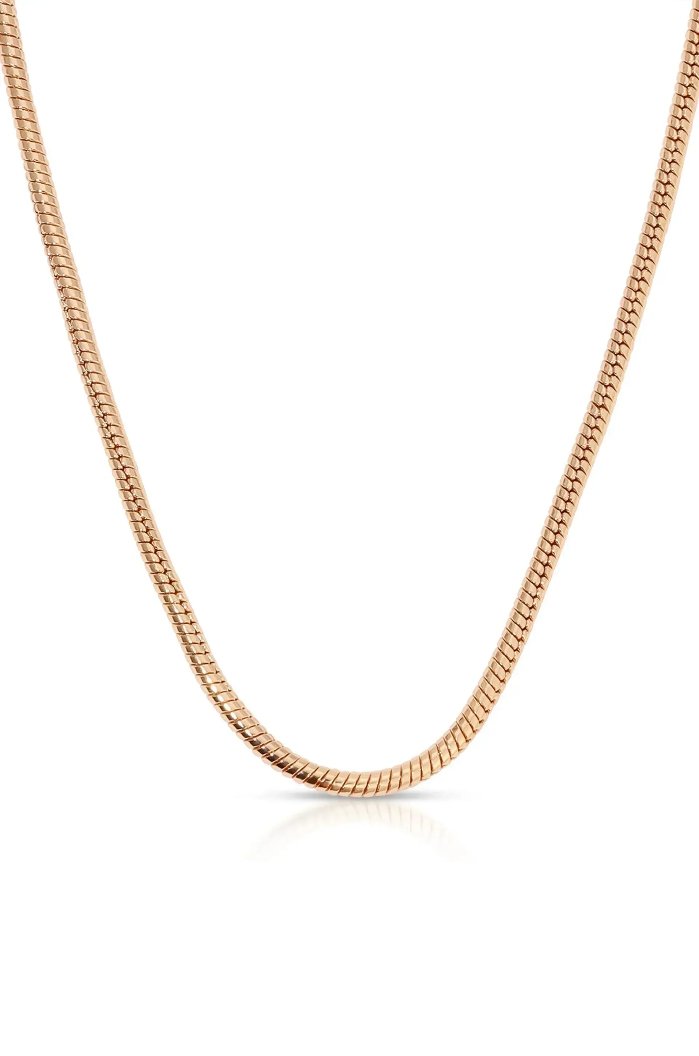 A shiny, rose gold chain rests against a reflective surface, depicting a smooth, flexible design that demonstrates elegance and simplicity in jewelry.