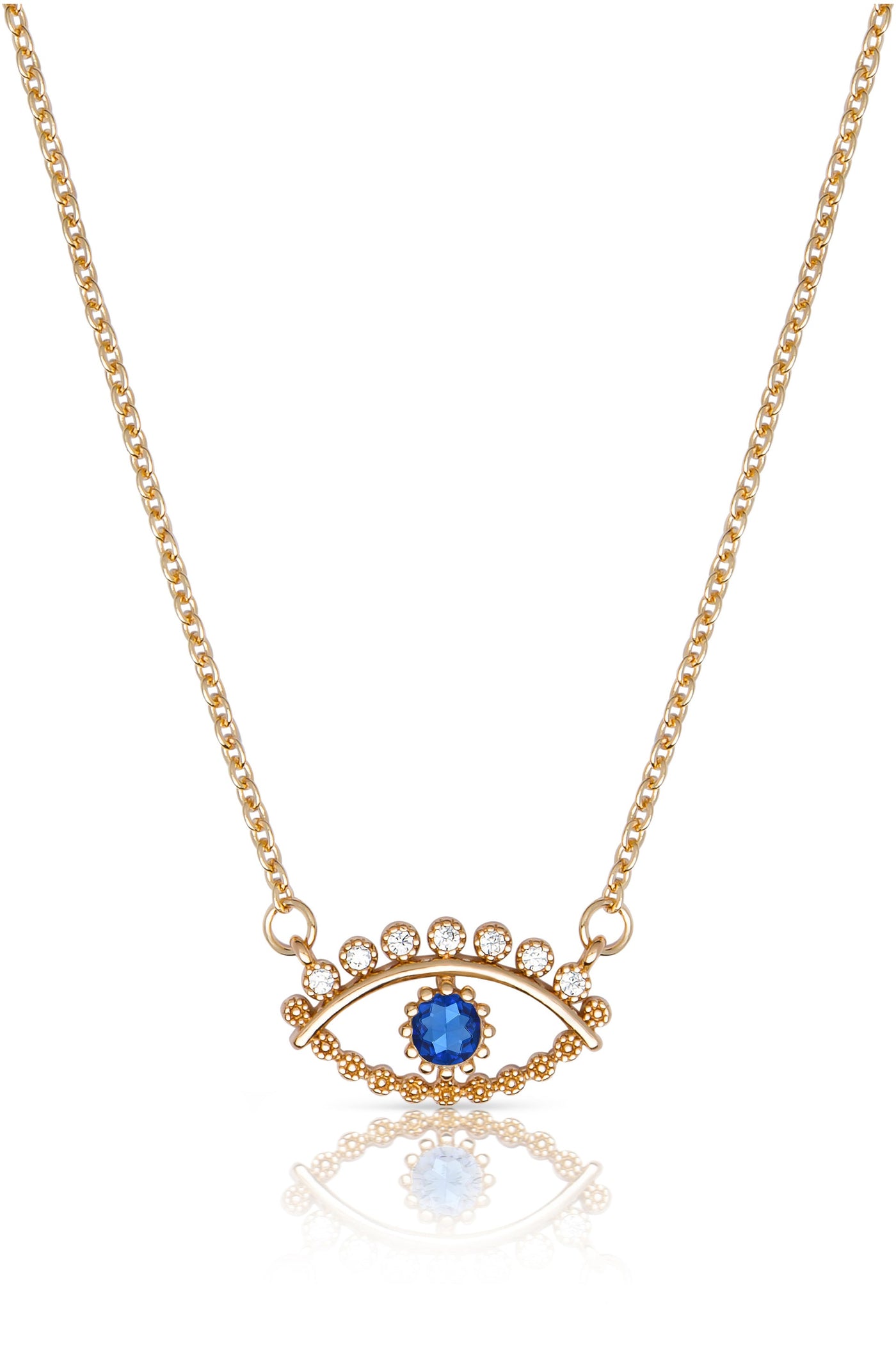 A golden necklace features a blue gemstone and sparkling circular decorations arranged in an eye shape, resting on a reflective surface, showcasing its intricate design and elegance.