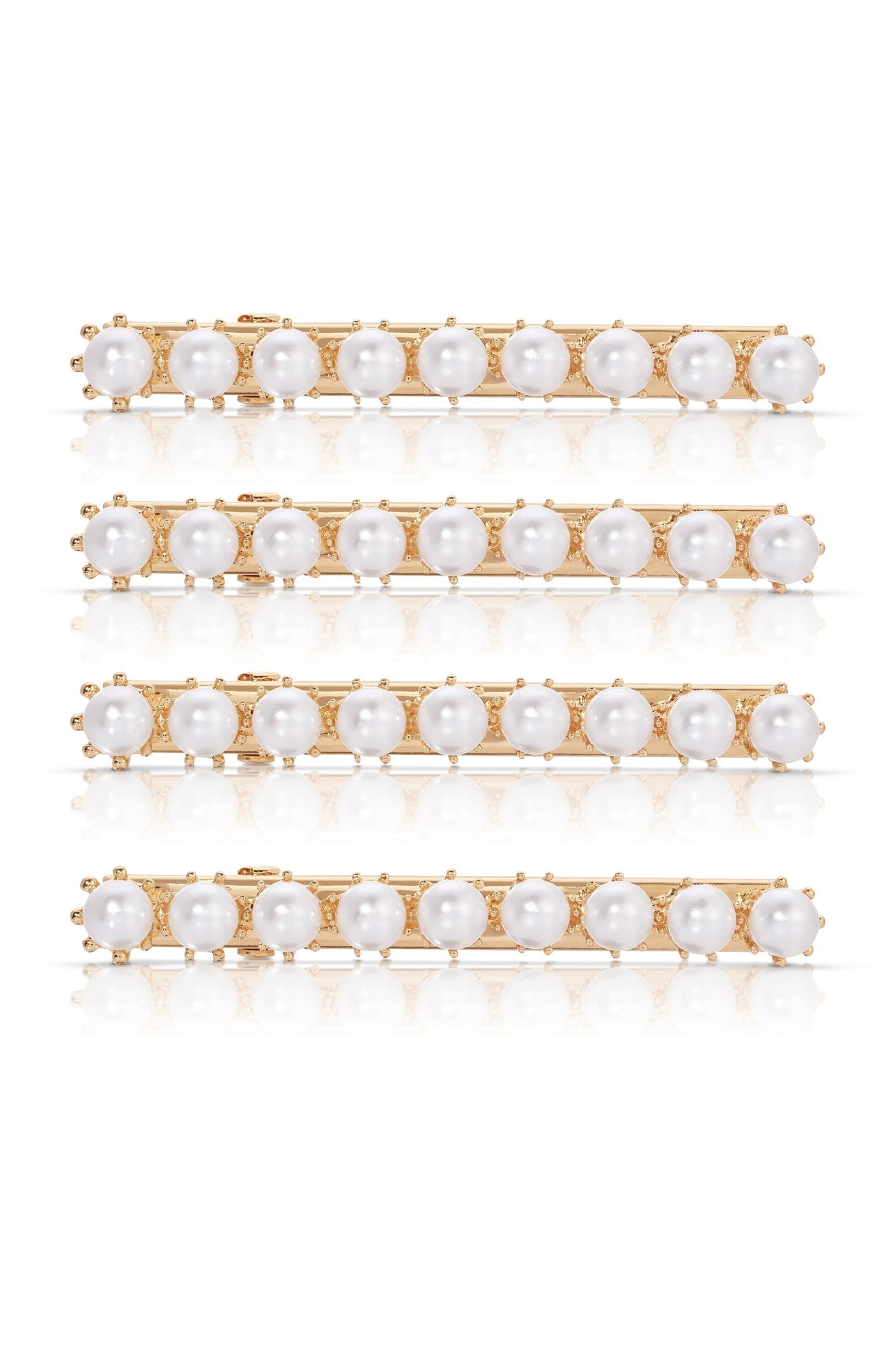 A set of four gold hairpins adorned with alternating white pearls and small decorative elements reflect light on a smooth surface, emphasizing their elegance and design.