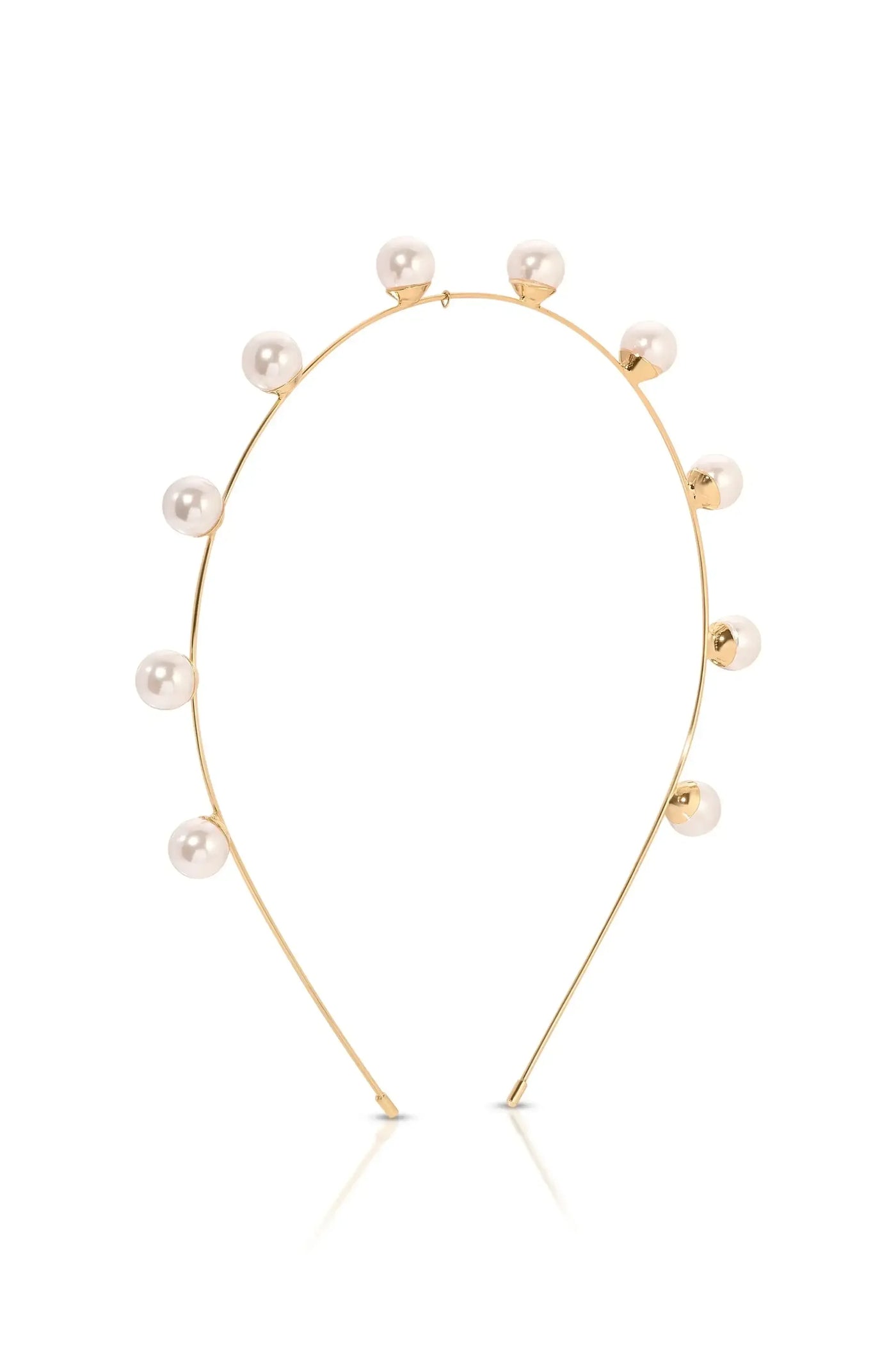 A minimalist golden headband features a curved design adorned with alternating small, shiny pearls. It rests against a plain white background, highlighting its elegance and simplicity.