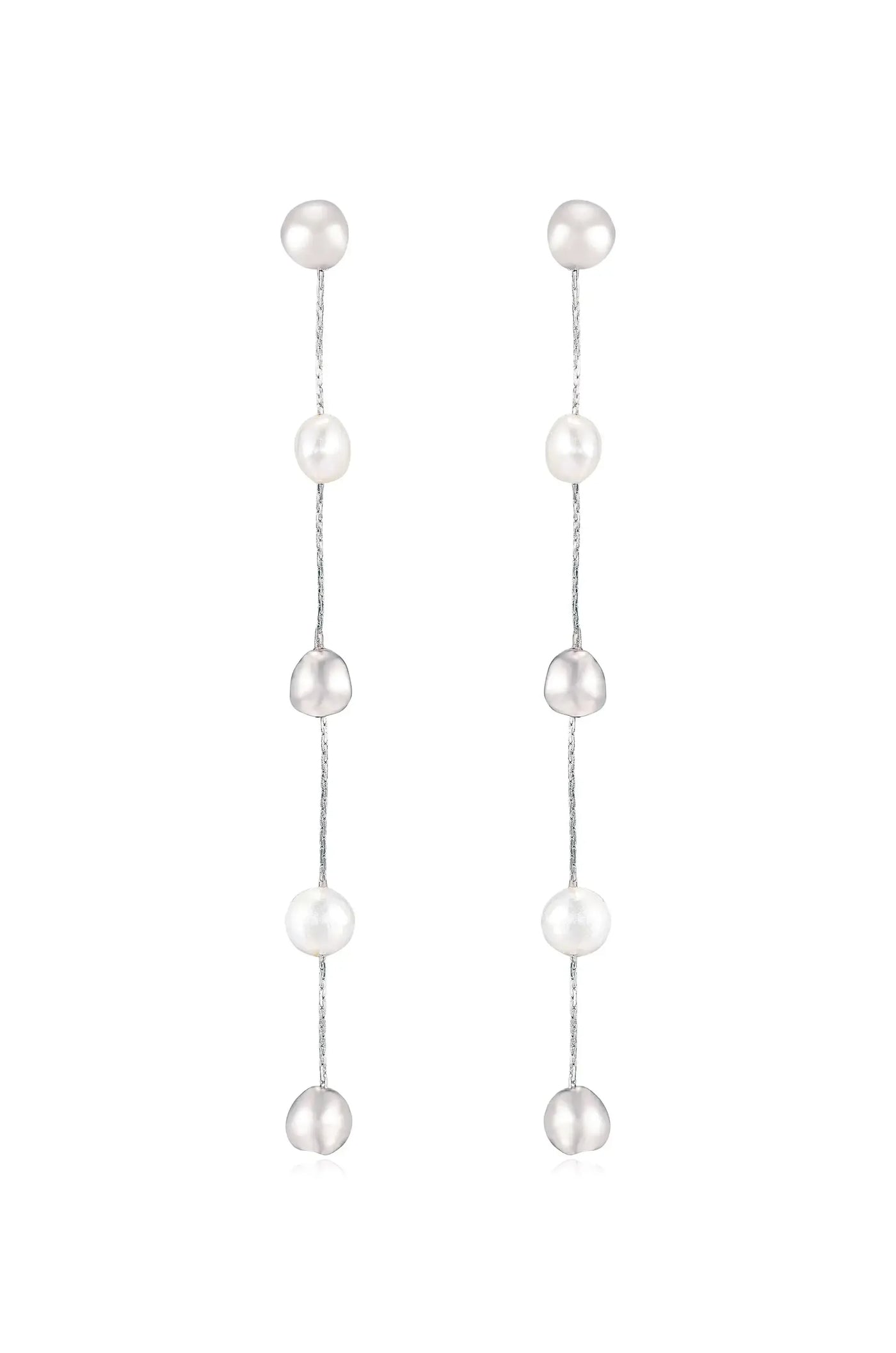Earrings made of pearls hang vertically on thin silver chains. The design features alternating round, shiny pearls in varying shades, creating an elegant appearance suitable for formal occasions.