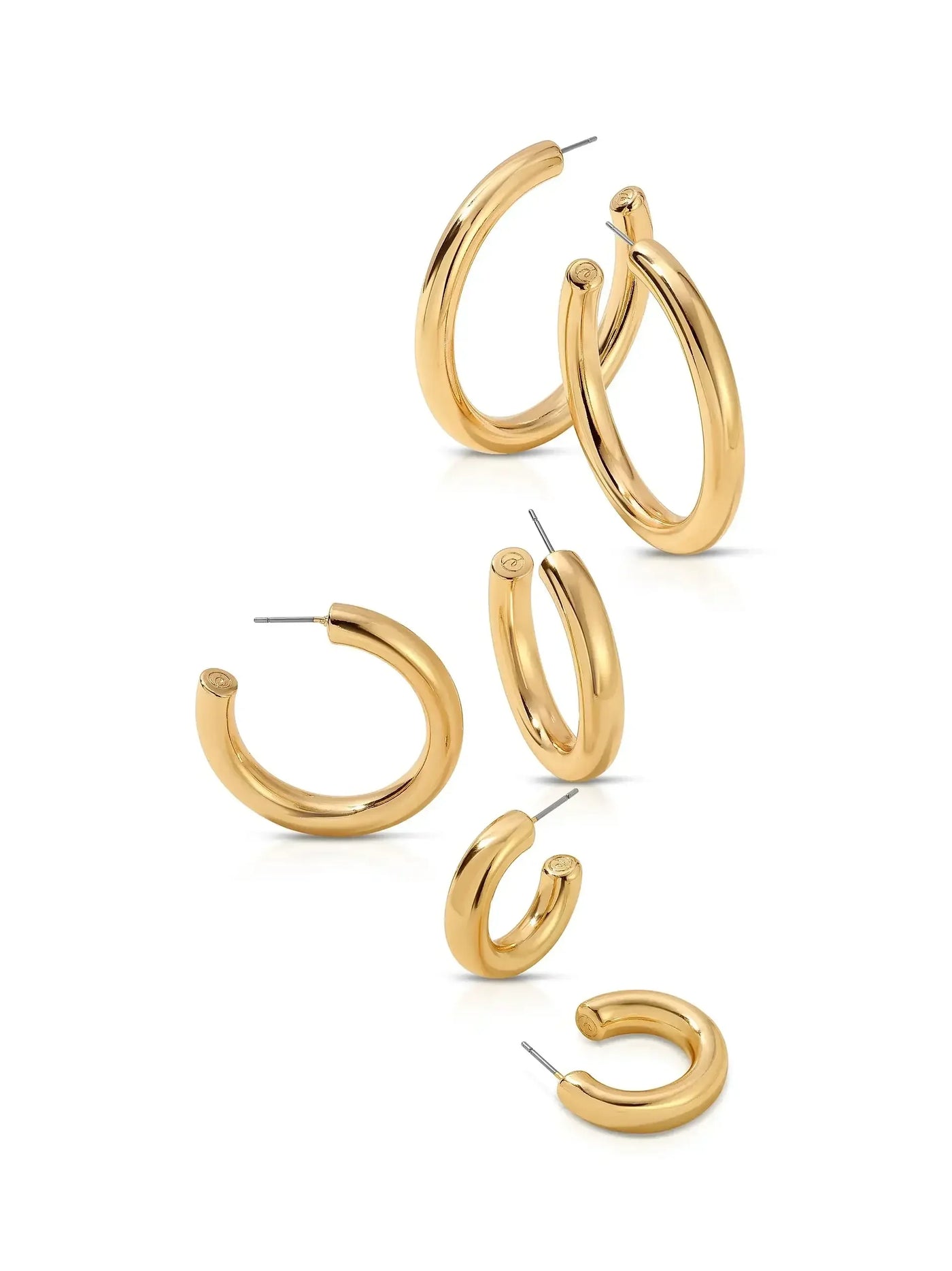 Three pairs of gold hoop earrings, varying in size, are displayed closely together on a white background, showcasing their shiny, curved designs and pin clasps.