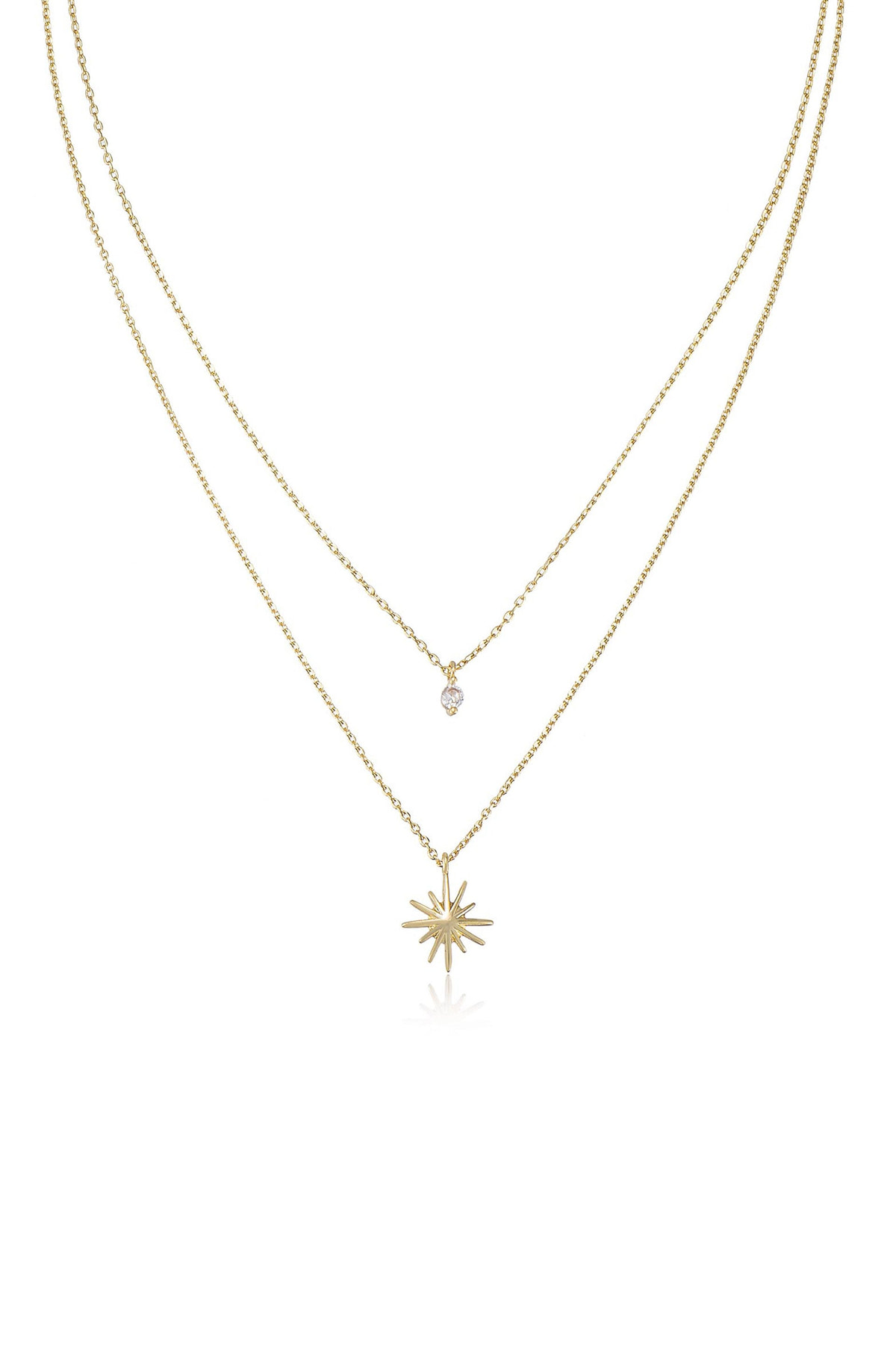 A gold necklace features two chains, one with a small sparkling stone and the other with a star-shaped pendant, displayed against a plain white background.