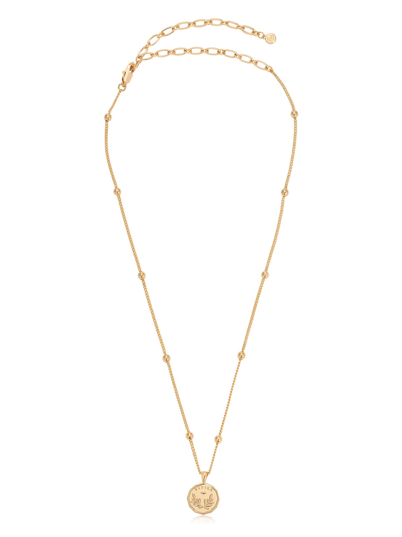 A delicate gold necklace features a circular pendant at the center. The chain consists of fine links and small beads, set against a neutral background, suggesting elegance and simplicity.