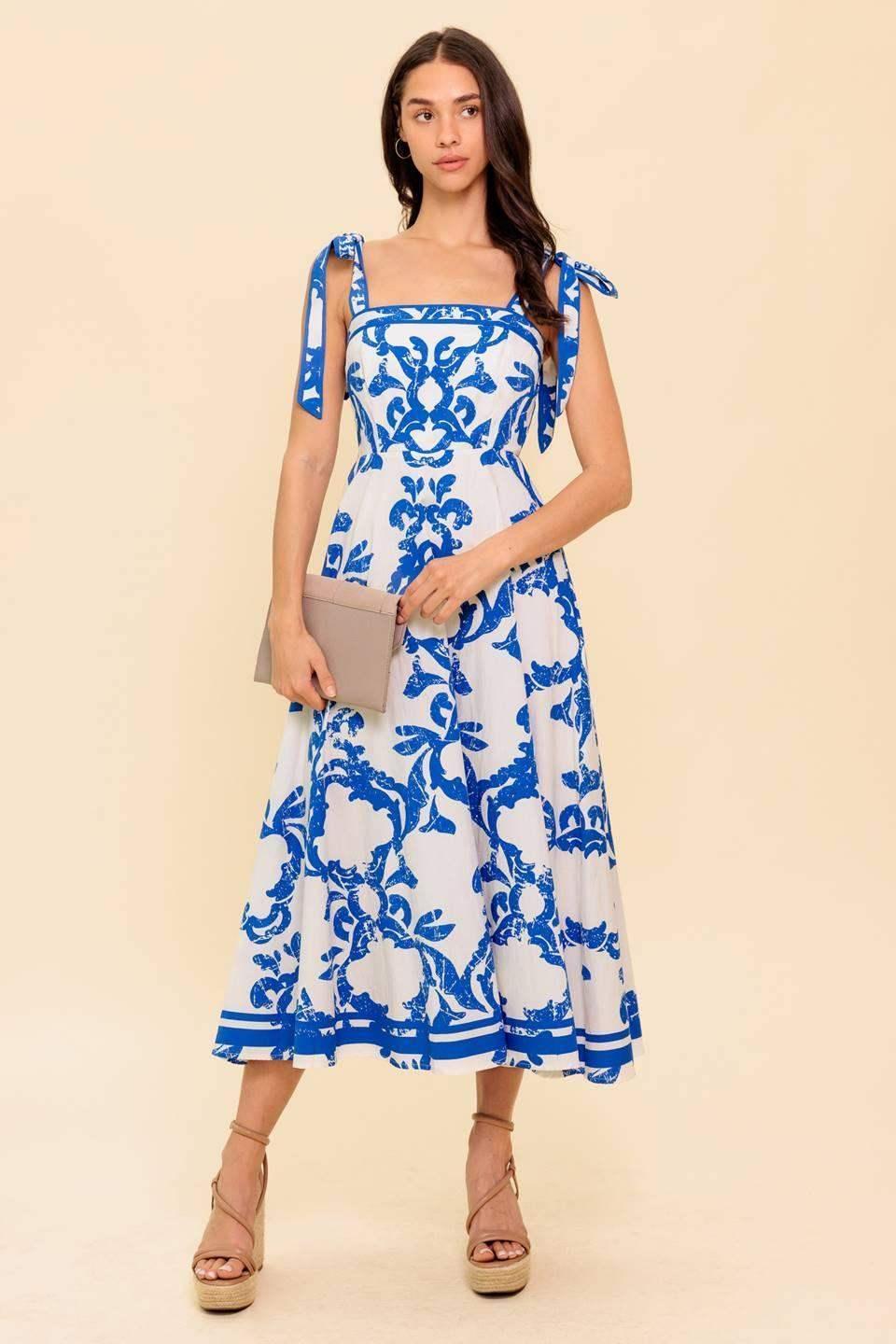 Blue and white floral midi dress with a straight neckline, shoulder straps, and a circle skirt.