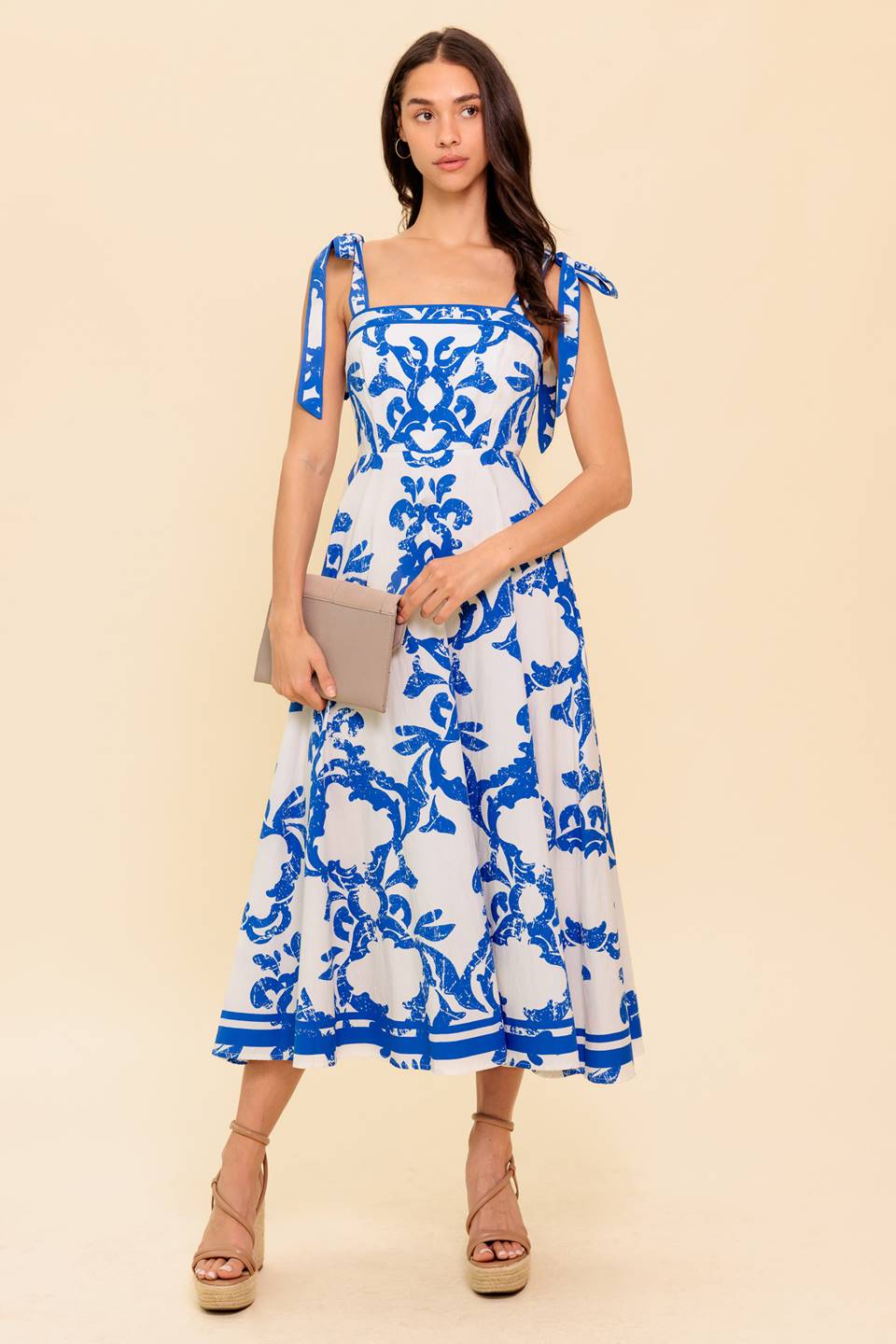 Blue and white floral midi dress with a straight neckline, shoulder straps, and a circle skirt.