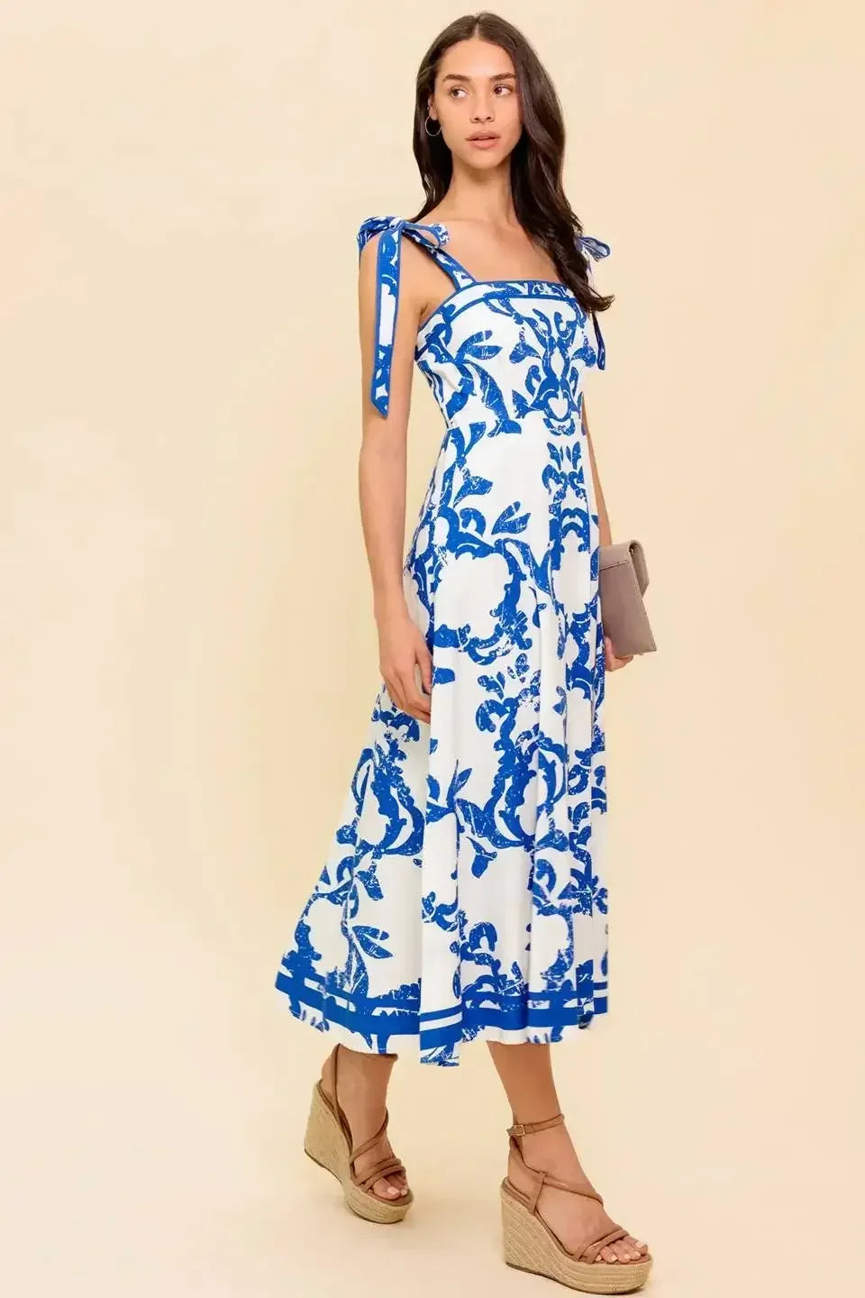 Blue and white floral midi dress with a straight neckline, shoulder straps, and a circle skirt.