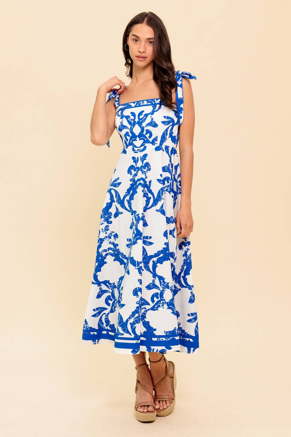 Blue and white floral midi dress with a straight neckline, shoulder straps, and a circle skirt.
