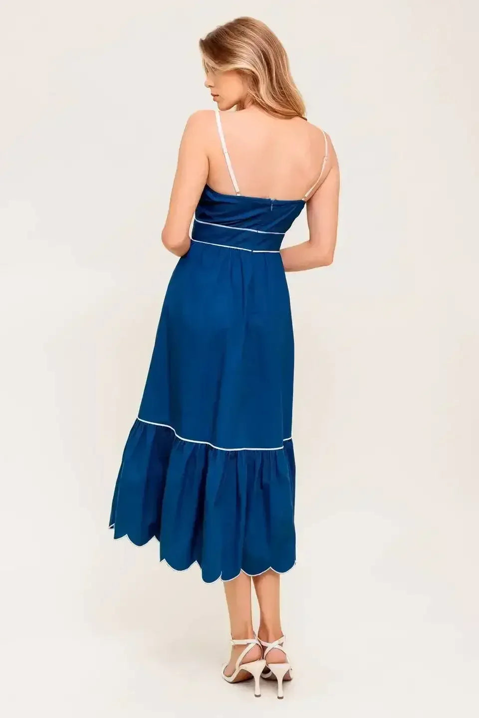 Navy midi dress with a scalloped neckline, sleeve straps, and a ruffled hemline