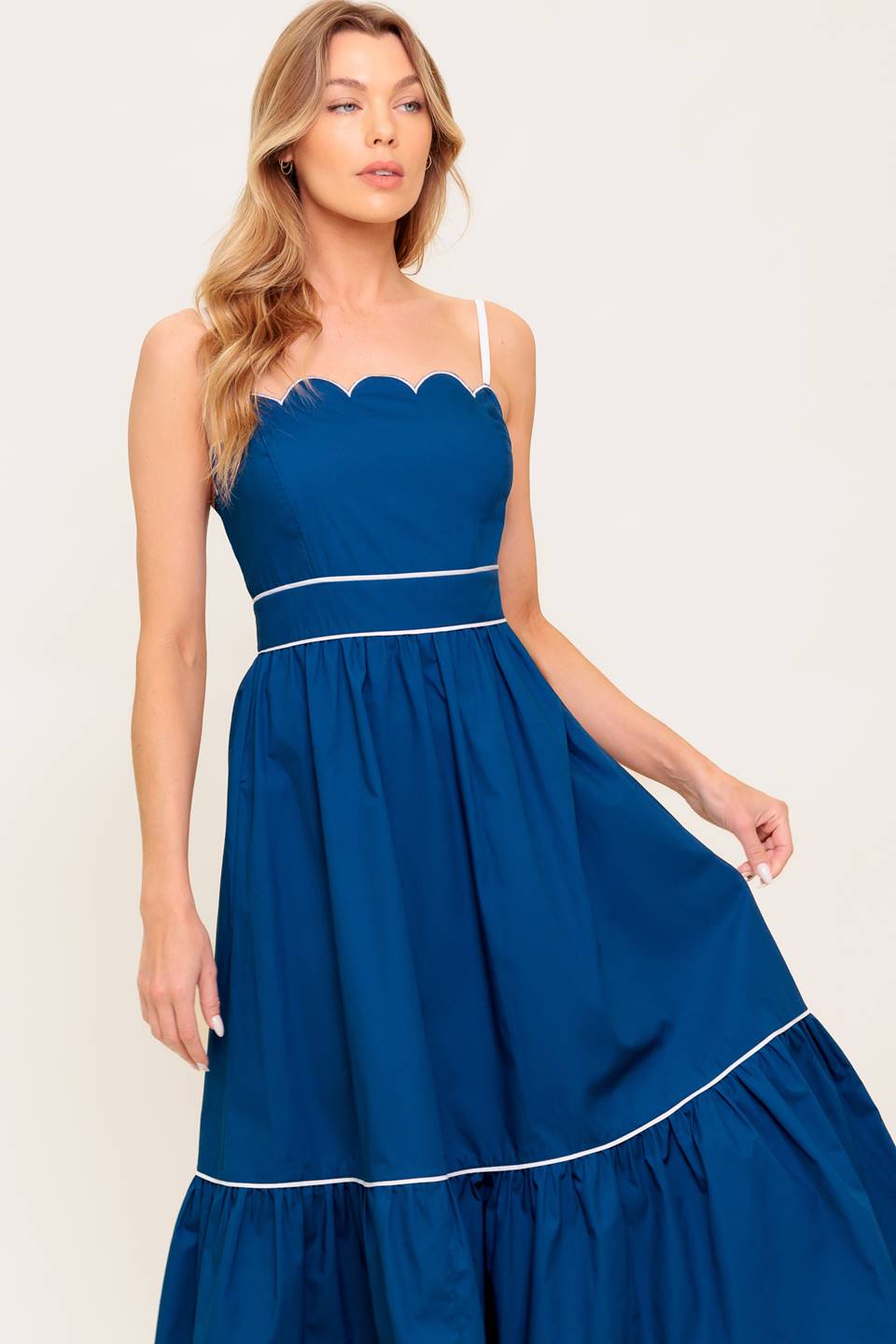 Navy midi dress with a scalloped neckline, sleeve straps, and a ruffled hemline