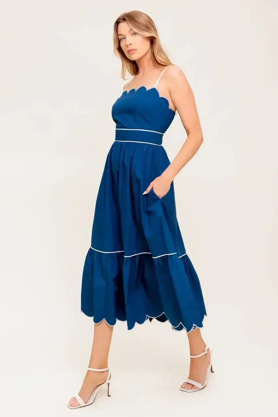 Navy midi dress with a scalloped neckline, sleeve straps, and a ruffled hemline